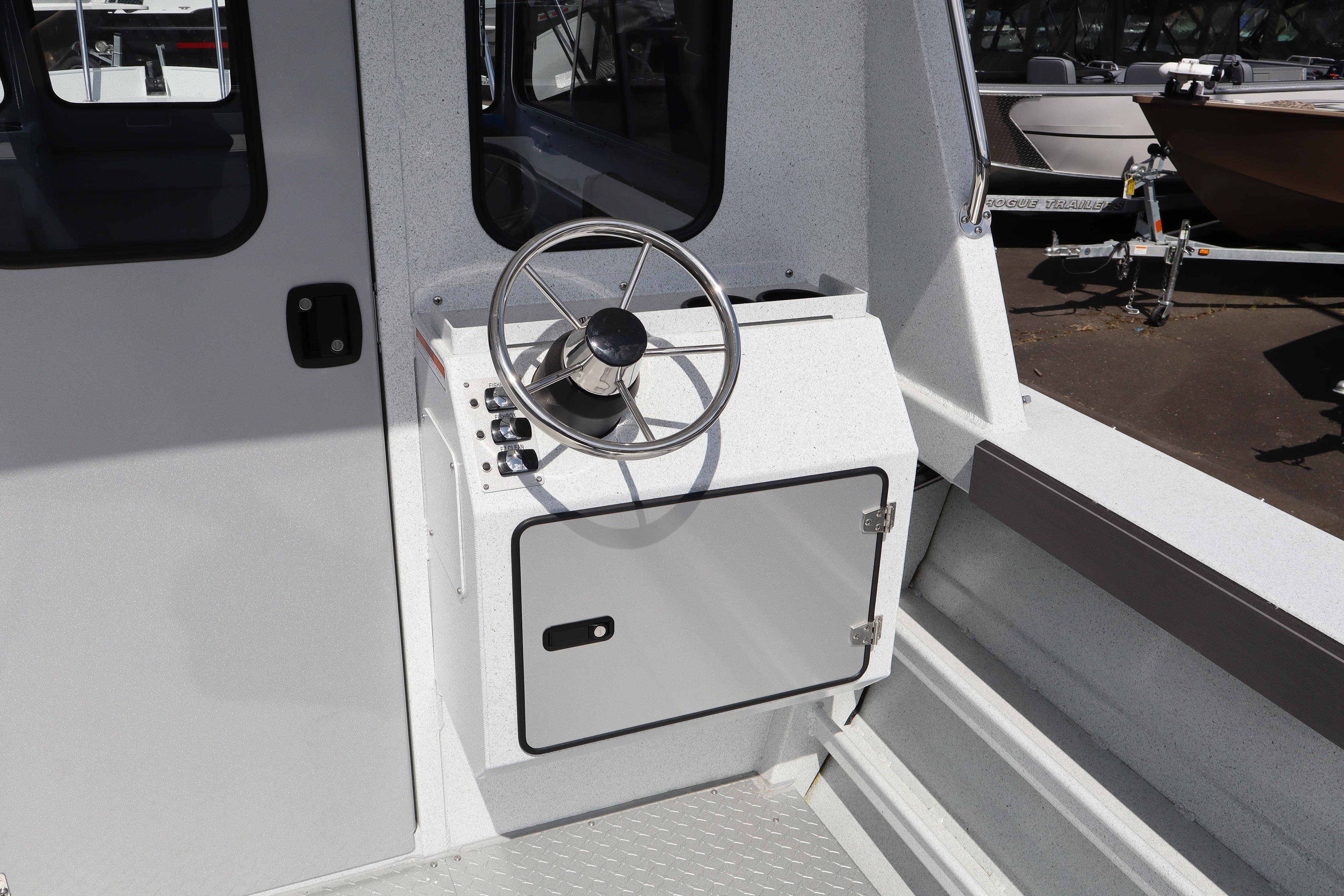 2026 KingFisher 2425 Escape HT boat helm with steering wheel and control panel.