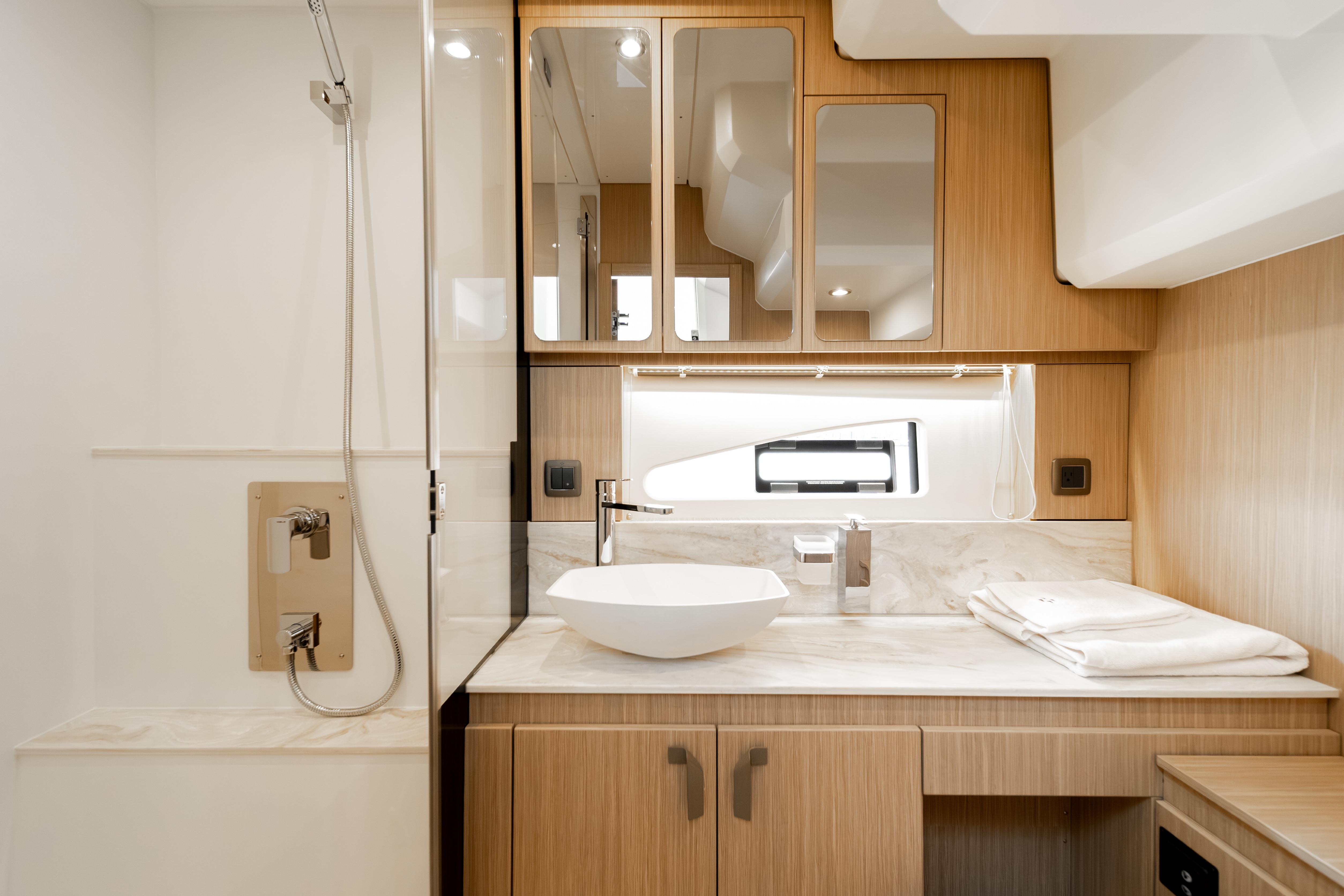 Luxurious bathroom in 2025 Prestige F4.9 yacht with modern fixtures and wooden cabinetry.
