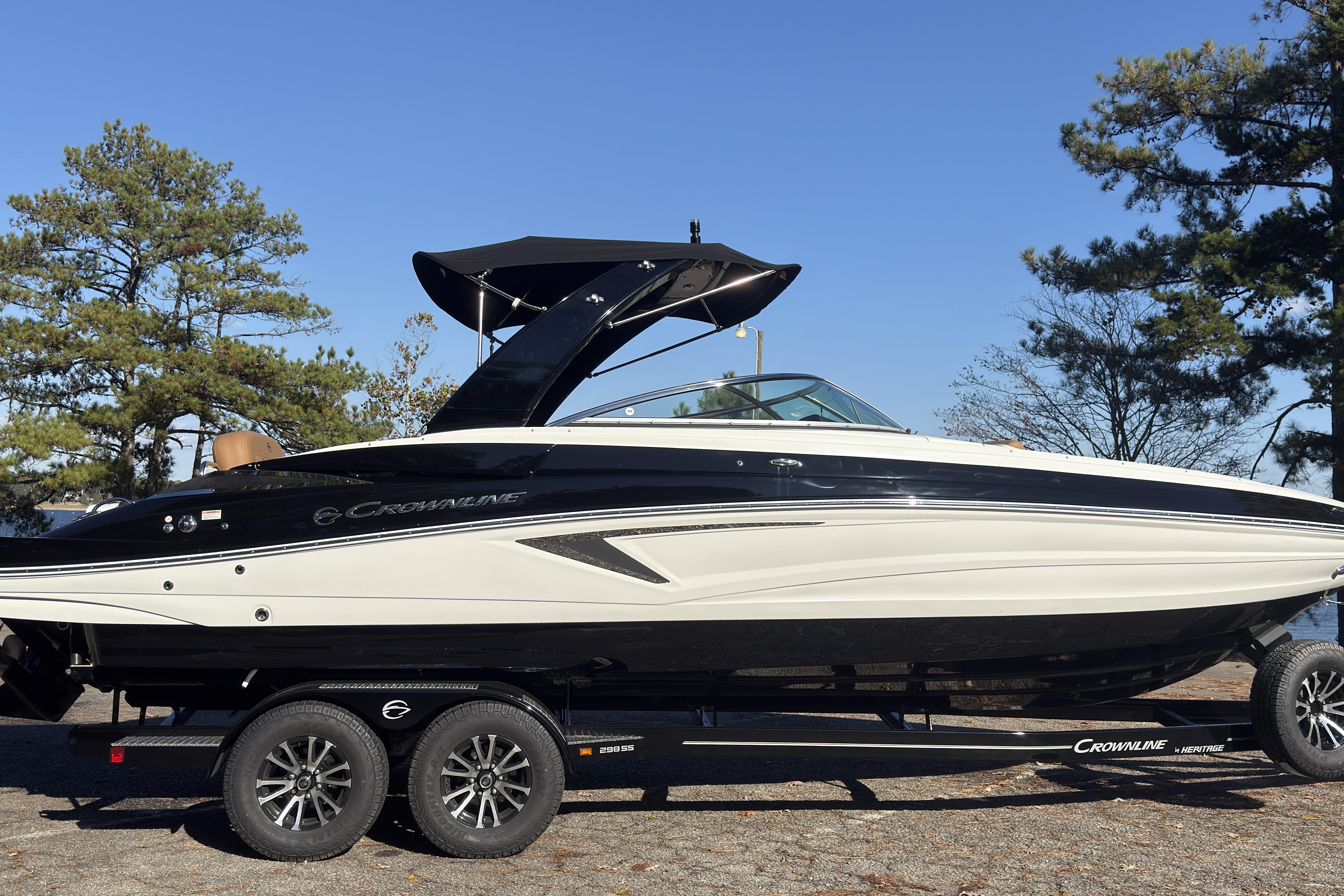 2026 Crownline 298 SS boat on trailer, parked outdoors with trees in background.