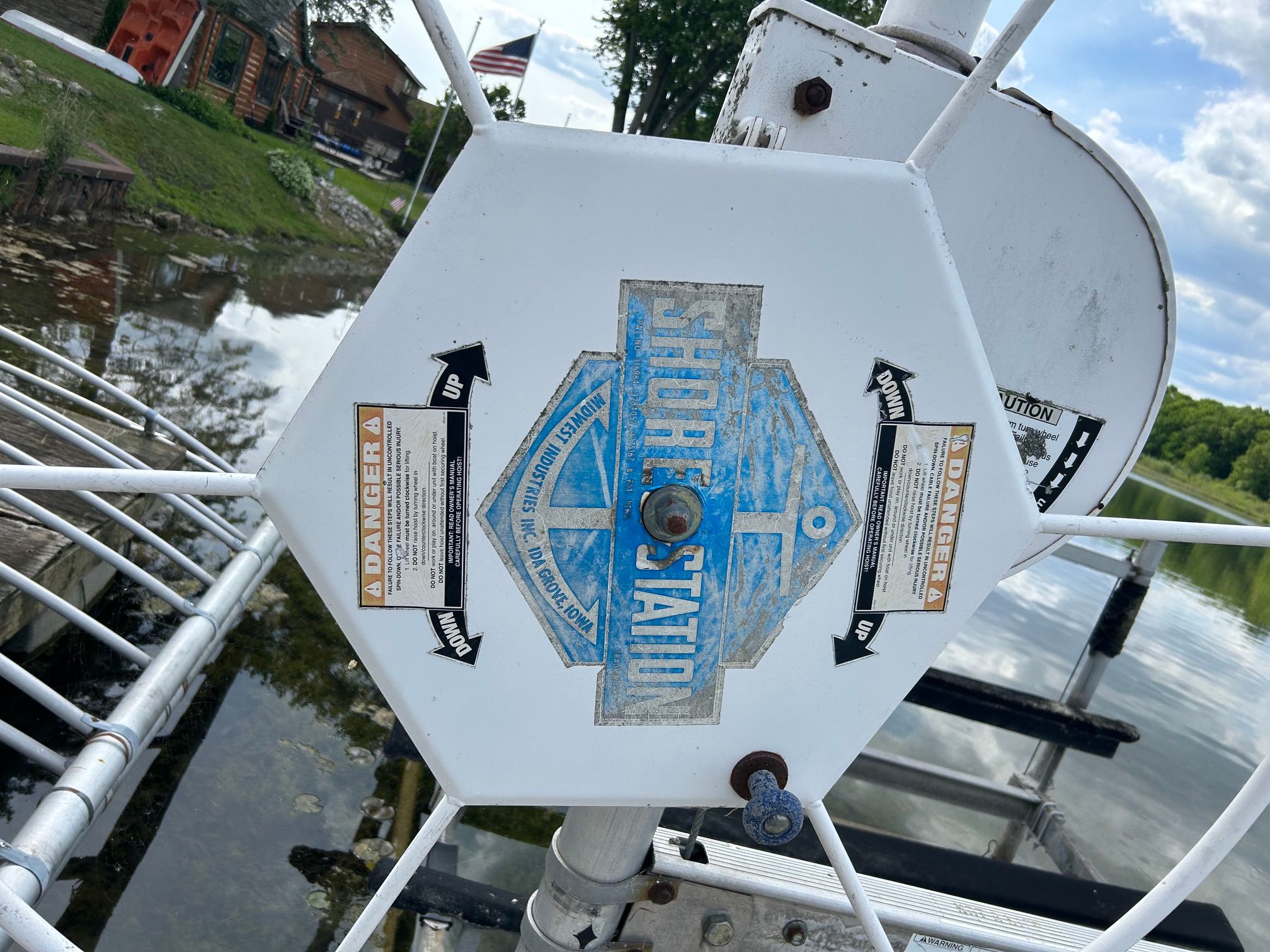 ShoreStation lift mechanism by water with warning labels.