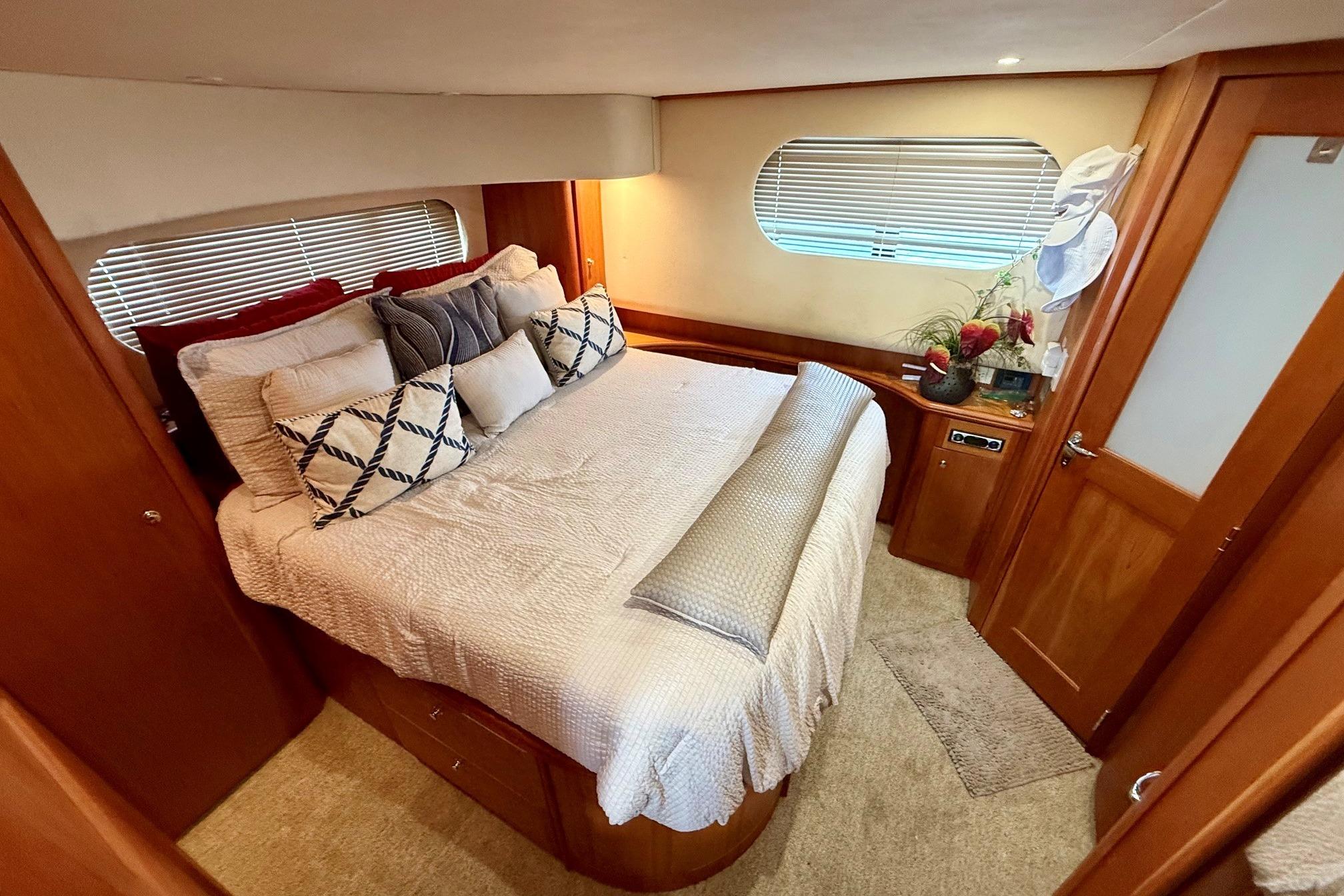 Luxurious bedroom interior of 2004 Silverton 39 Motor Yacht with elegant bedding and decor.