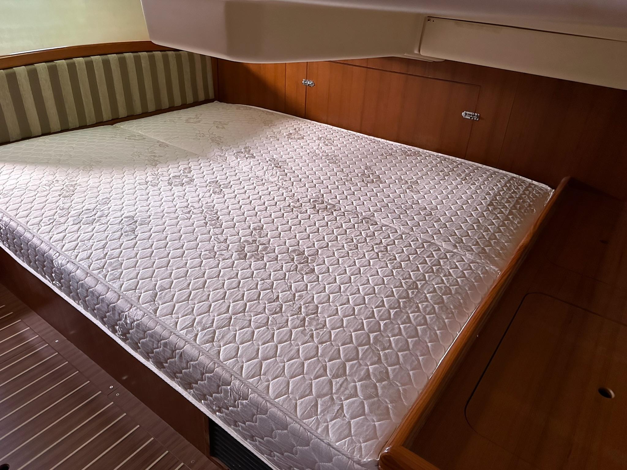 Cabin interior of 2005 Hunter 38 sailboat with a spacious bed.