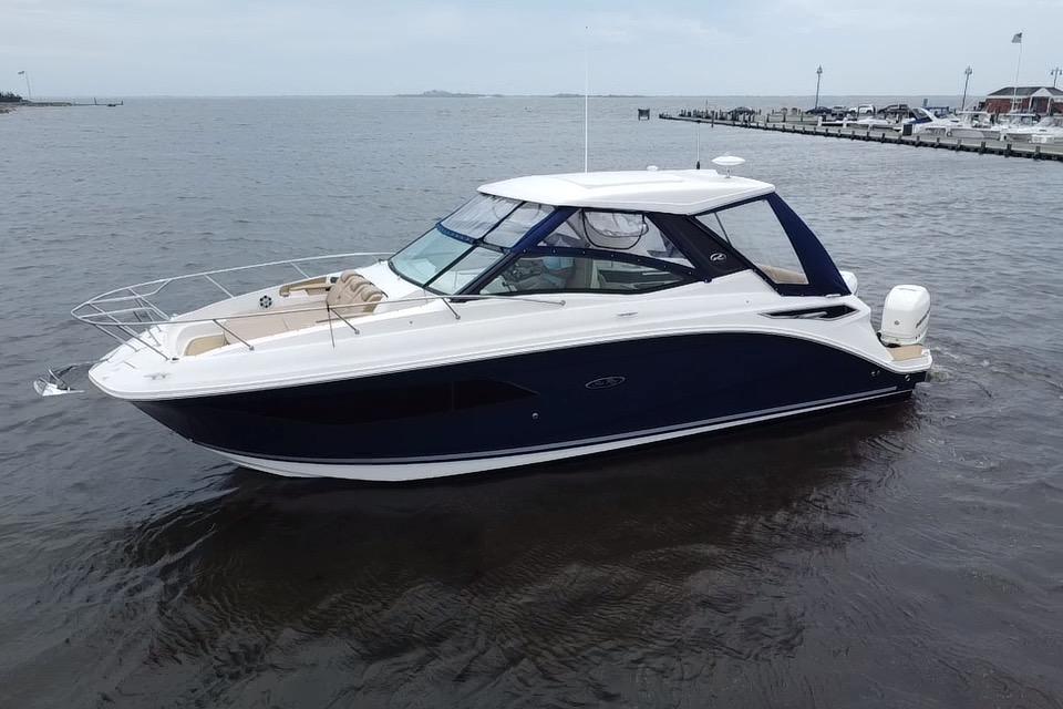 2021 Sea Ray Sundancer 320 Outboard cruising on calm waters near a marina.