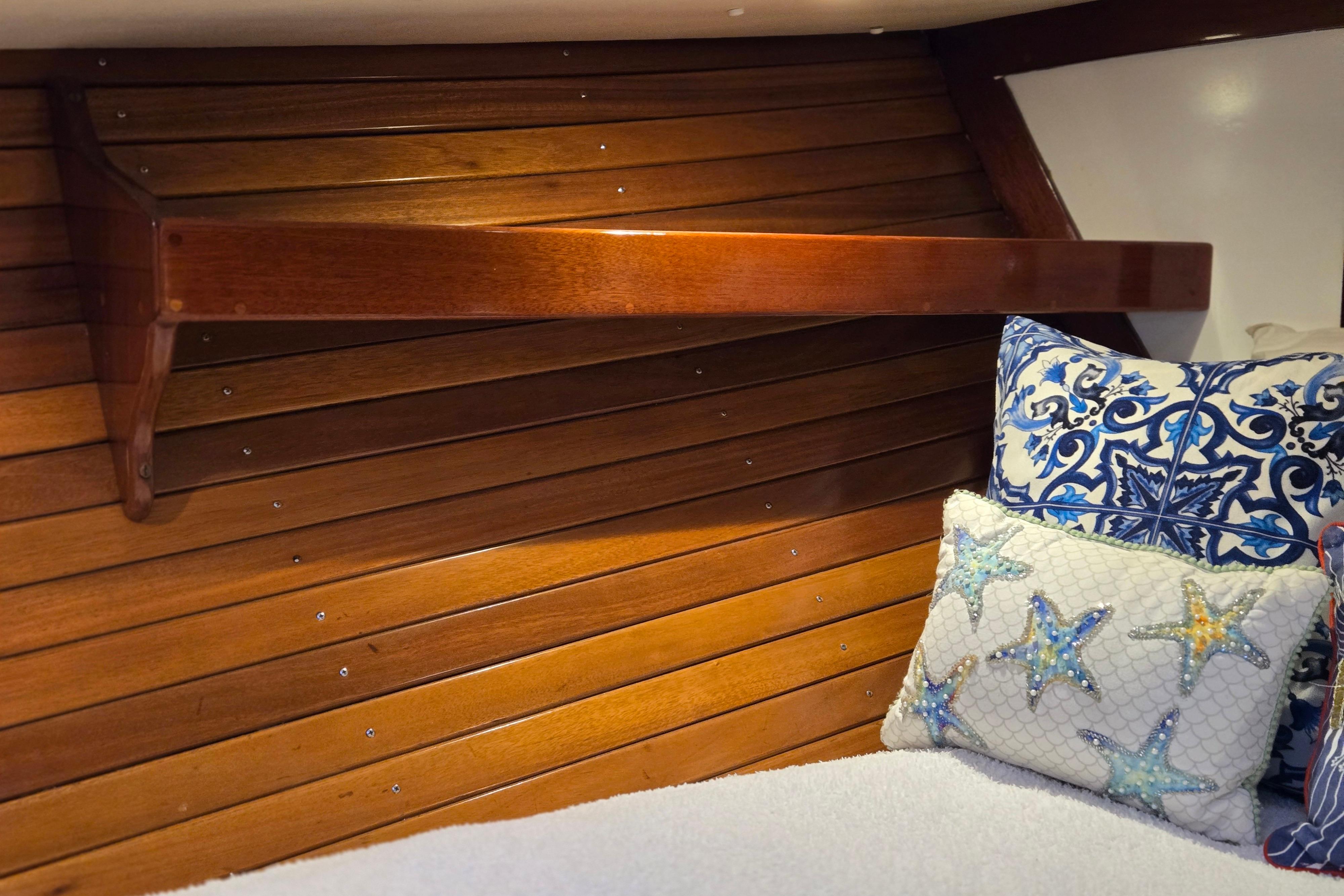 Cozy interior of 1970 Hinckley Bermuda 40 with wooden paneling and decorative pillows.
