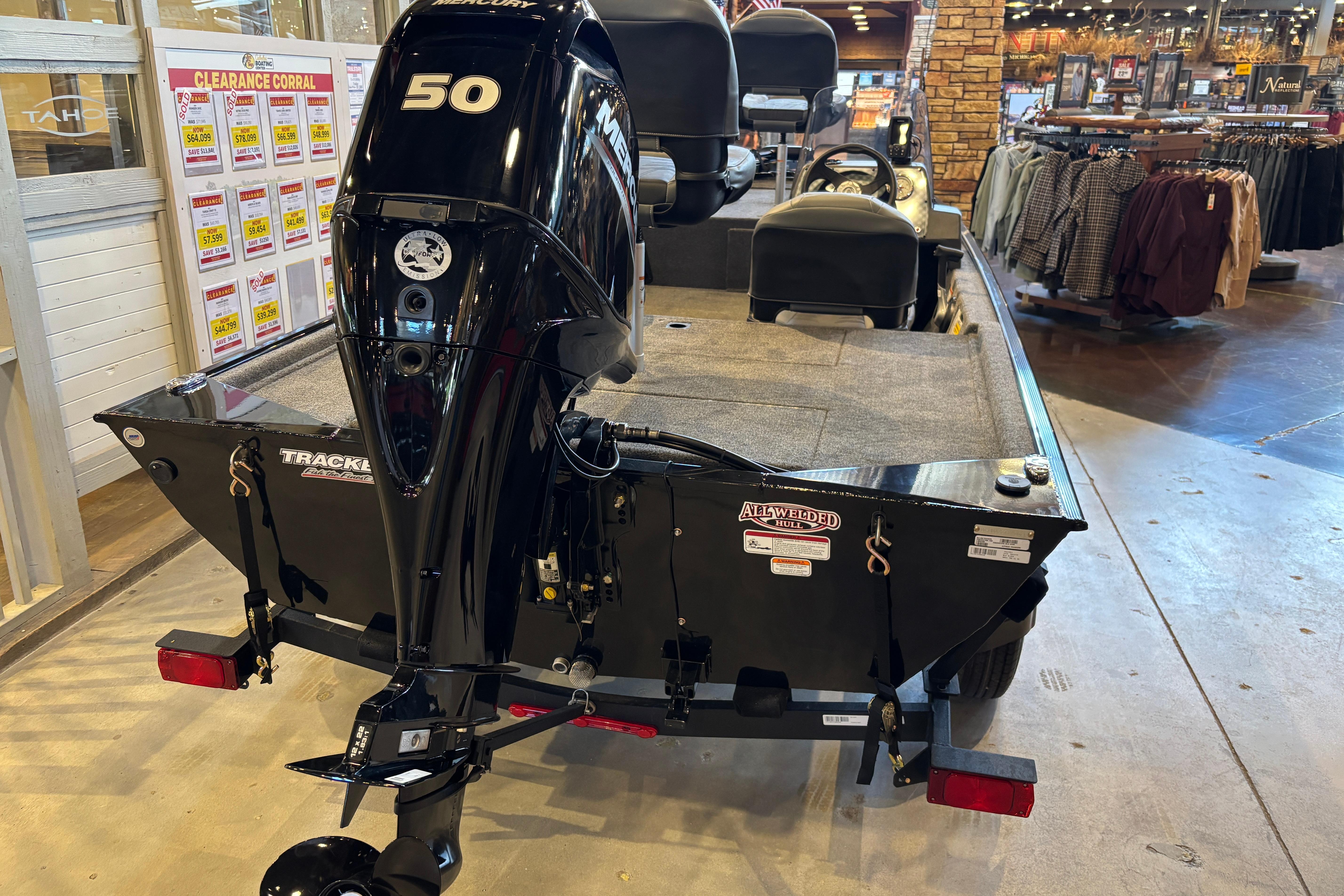 2026 Tracker Bass Tracker Classic XL boat displayed indoors with a powerful Mercury engine.
