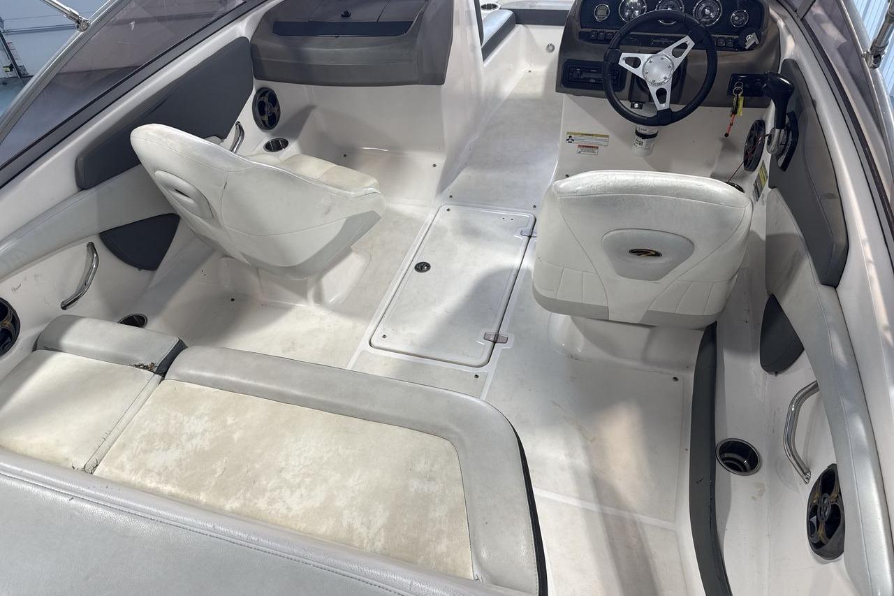 Interior of a 2012 Regal 1900 Bowrider boat with white seating and steering console.