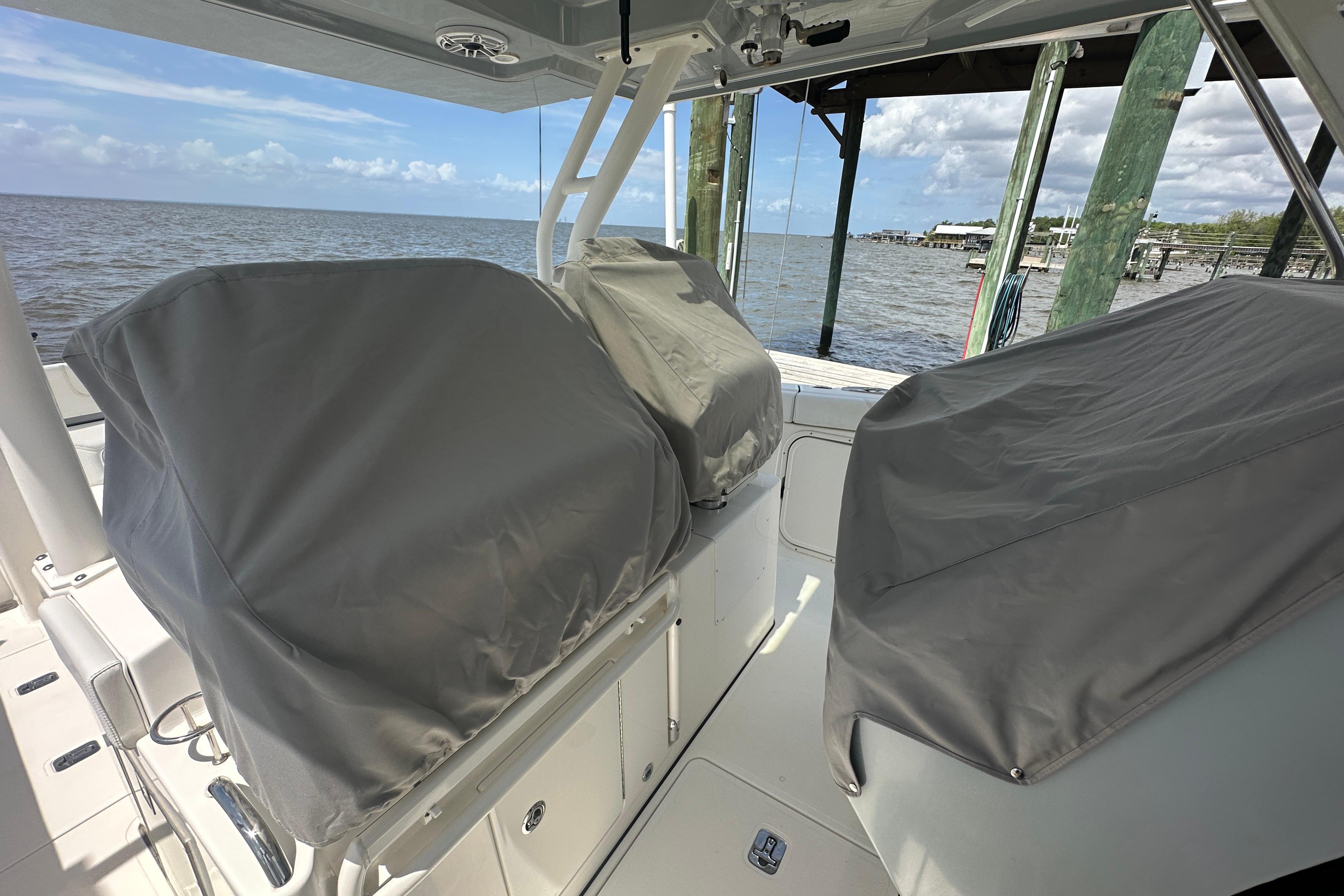 2021 Pursuit S 328 Sport boat interior with covered seats, docked by the water.