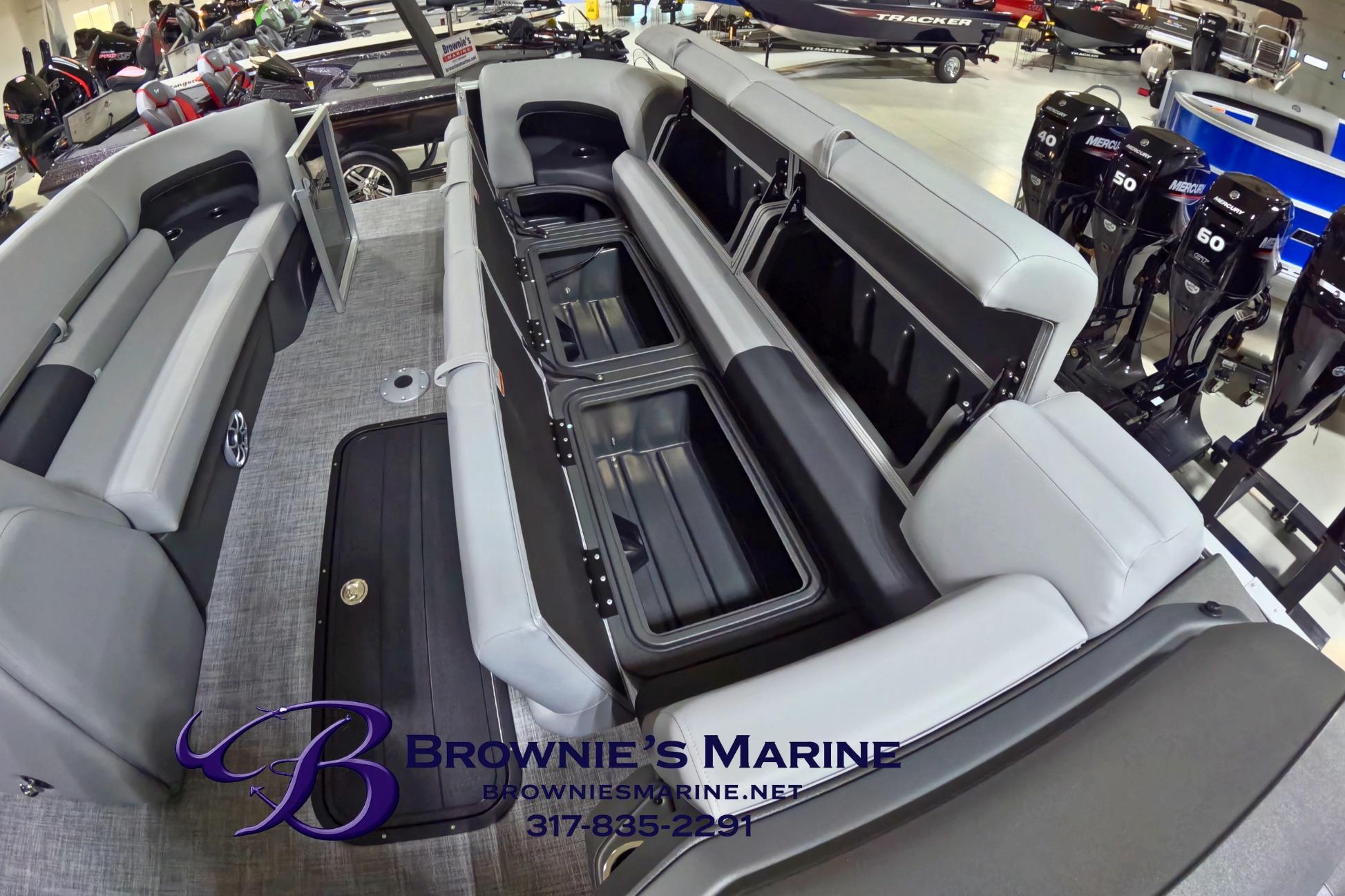 2026 Sun Tracker Party Barge 24 XP3 interior with open storage compartments at Brownie's Marine showroom.