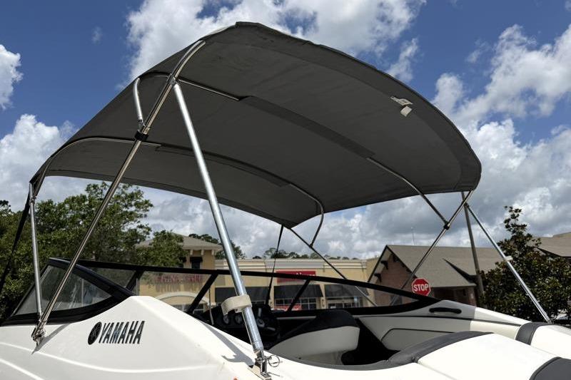 2017 Yamaha Boats SX210 with canopy under a partly cloudy sky.