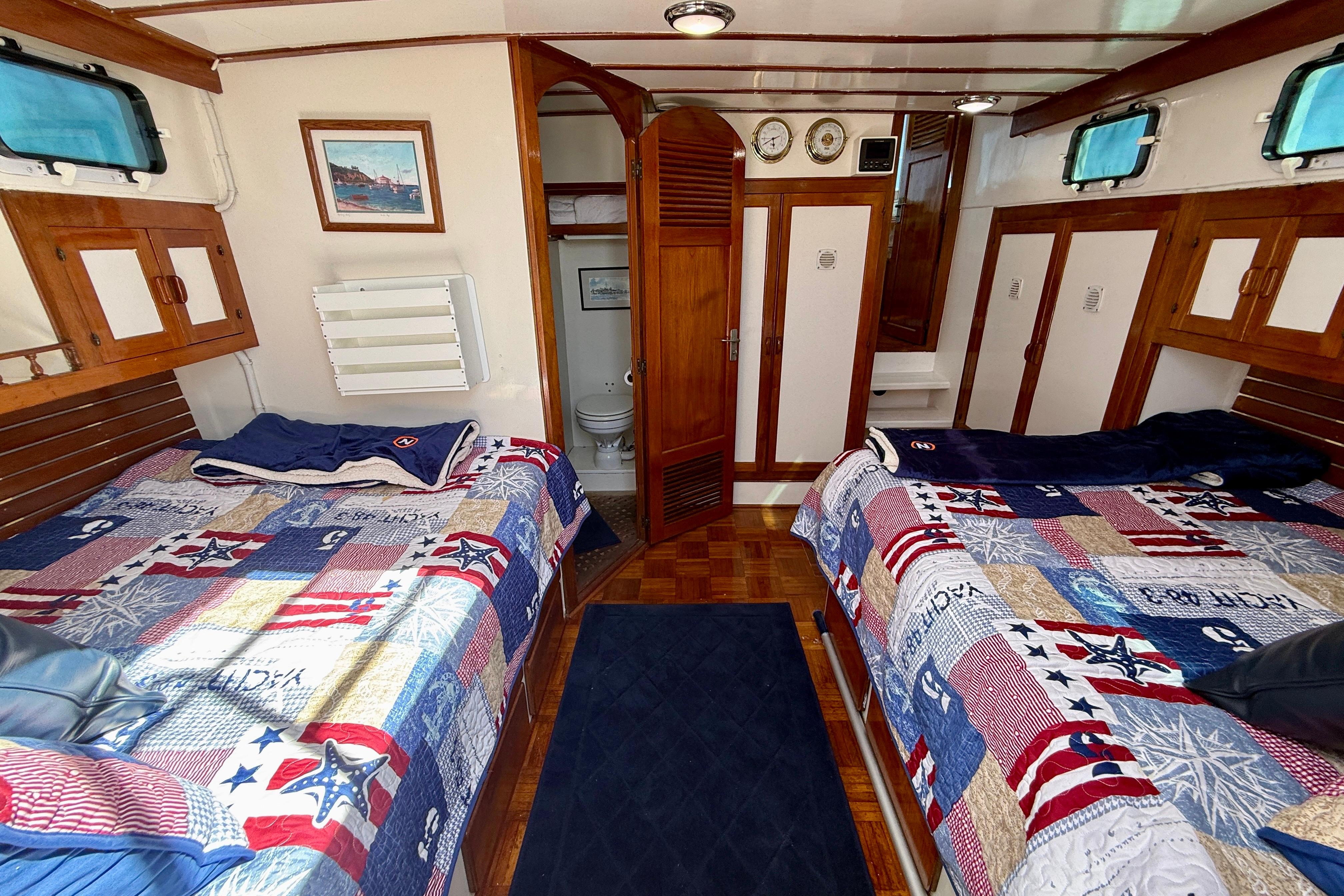 Interior of 1980 Roughwater 41 boat with twin beds and nautical decor.
