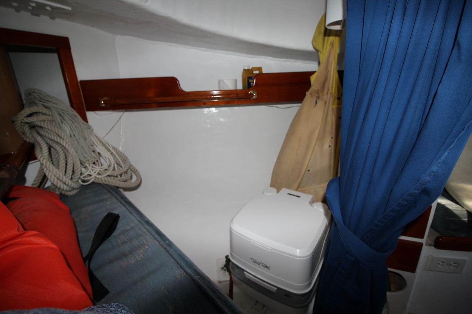 Interior of a 1974 Marshall 22 Cape Cod Catboat with ropes and portable toilet.