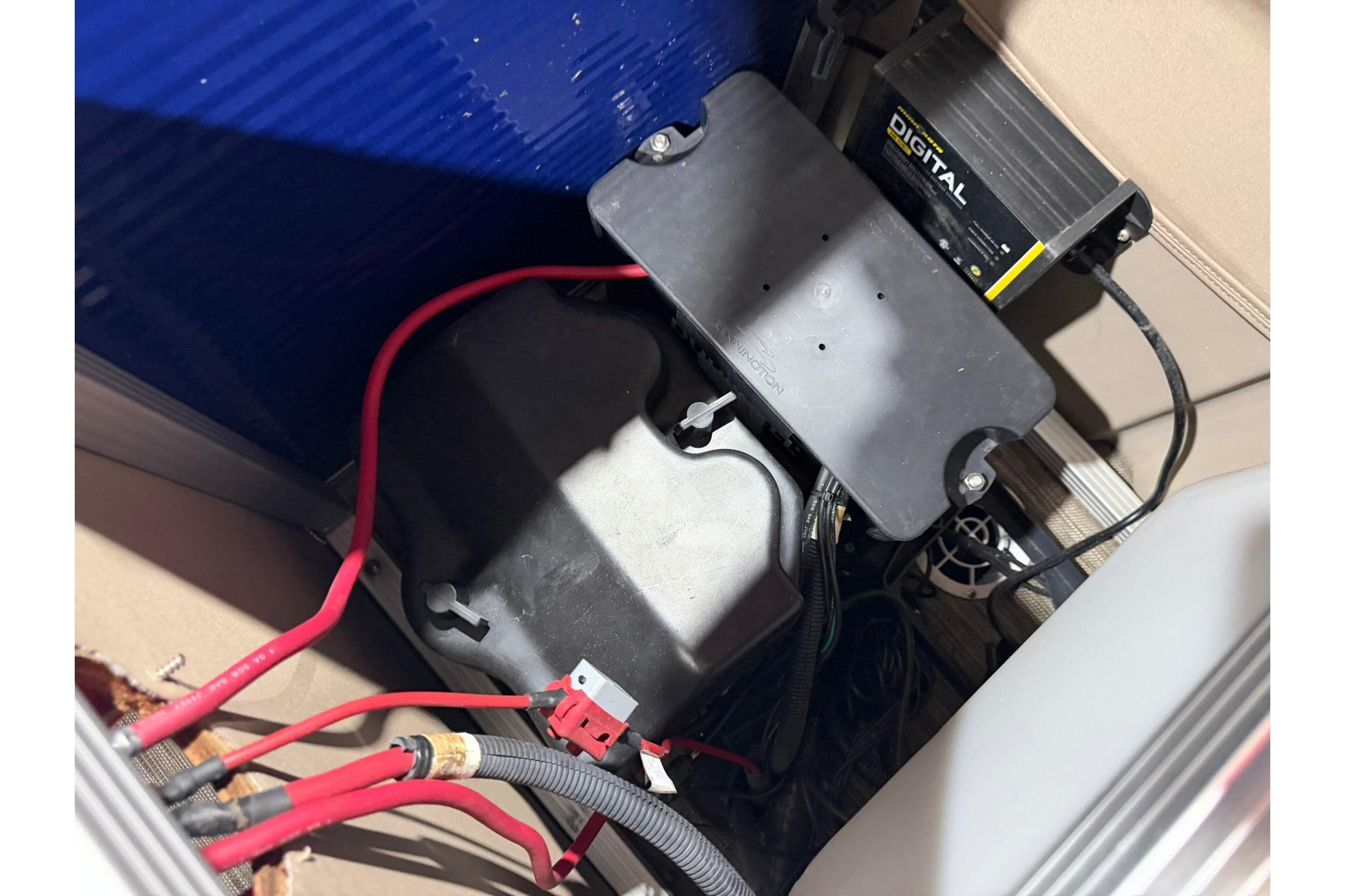 Battery compartment of a 2020 Bennington SX 22 SFX with digital charger and wiring.