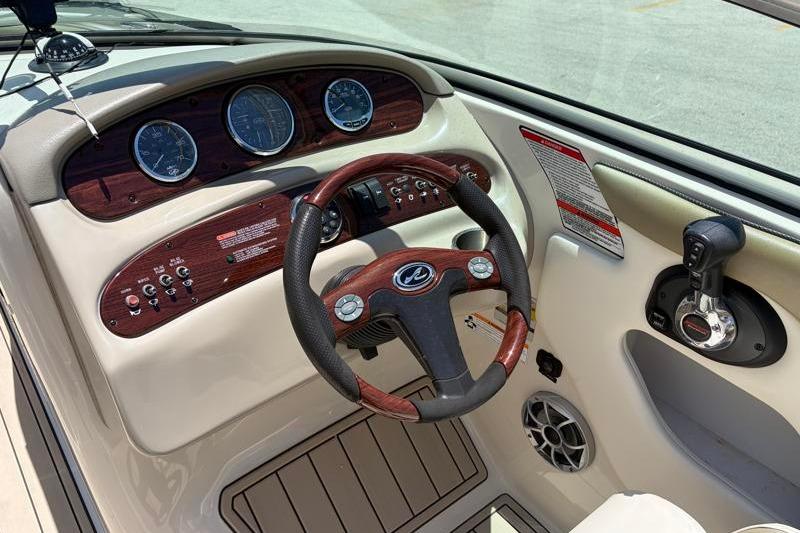 2007 Sea Ray 240 Sundeck dashboard with steering wheel and control panel.