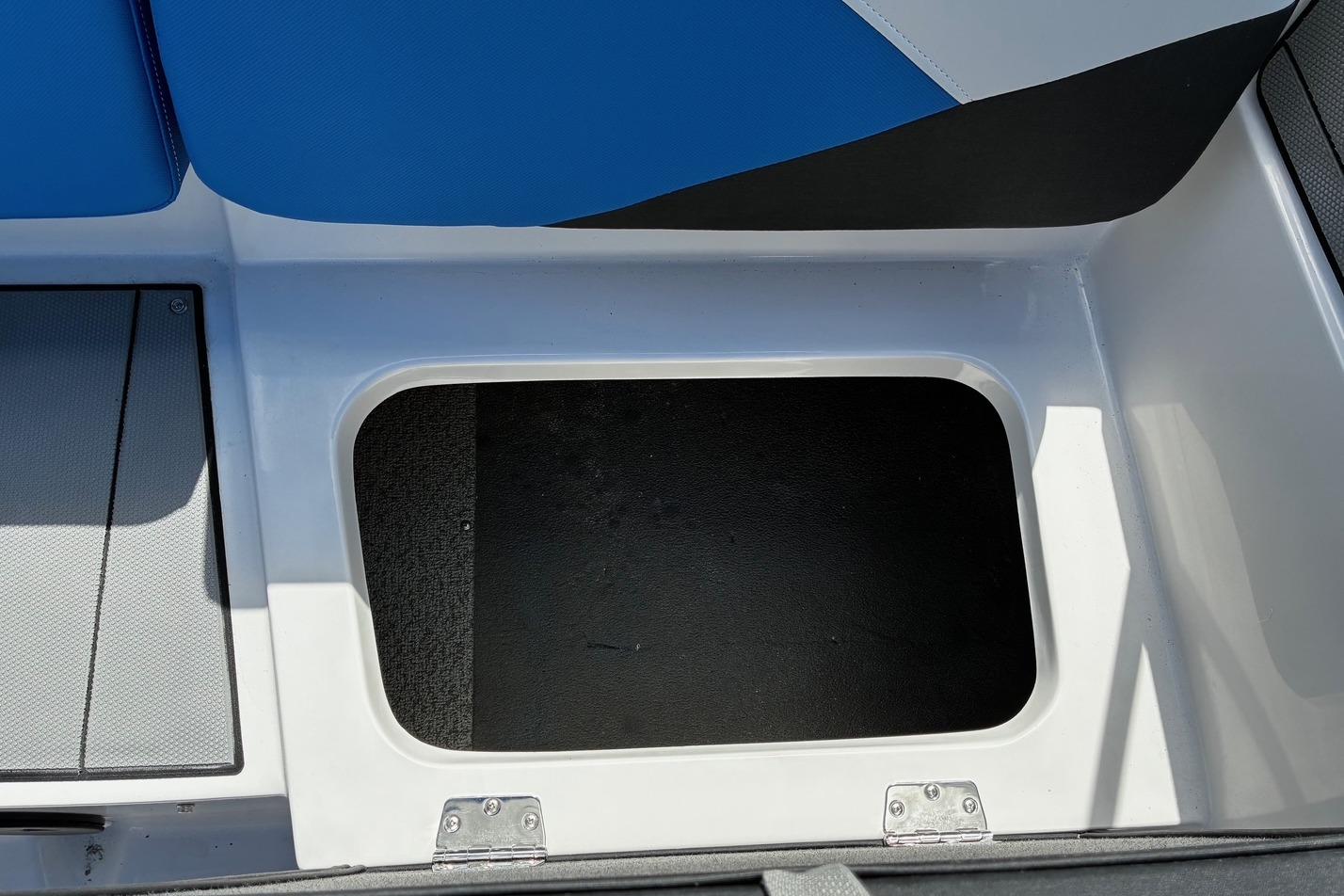 Open storage compartment on 2026 Starcraft SV 16 OB boat with blue seating.