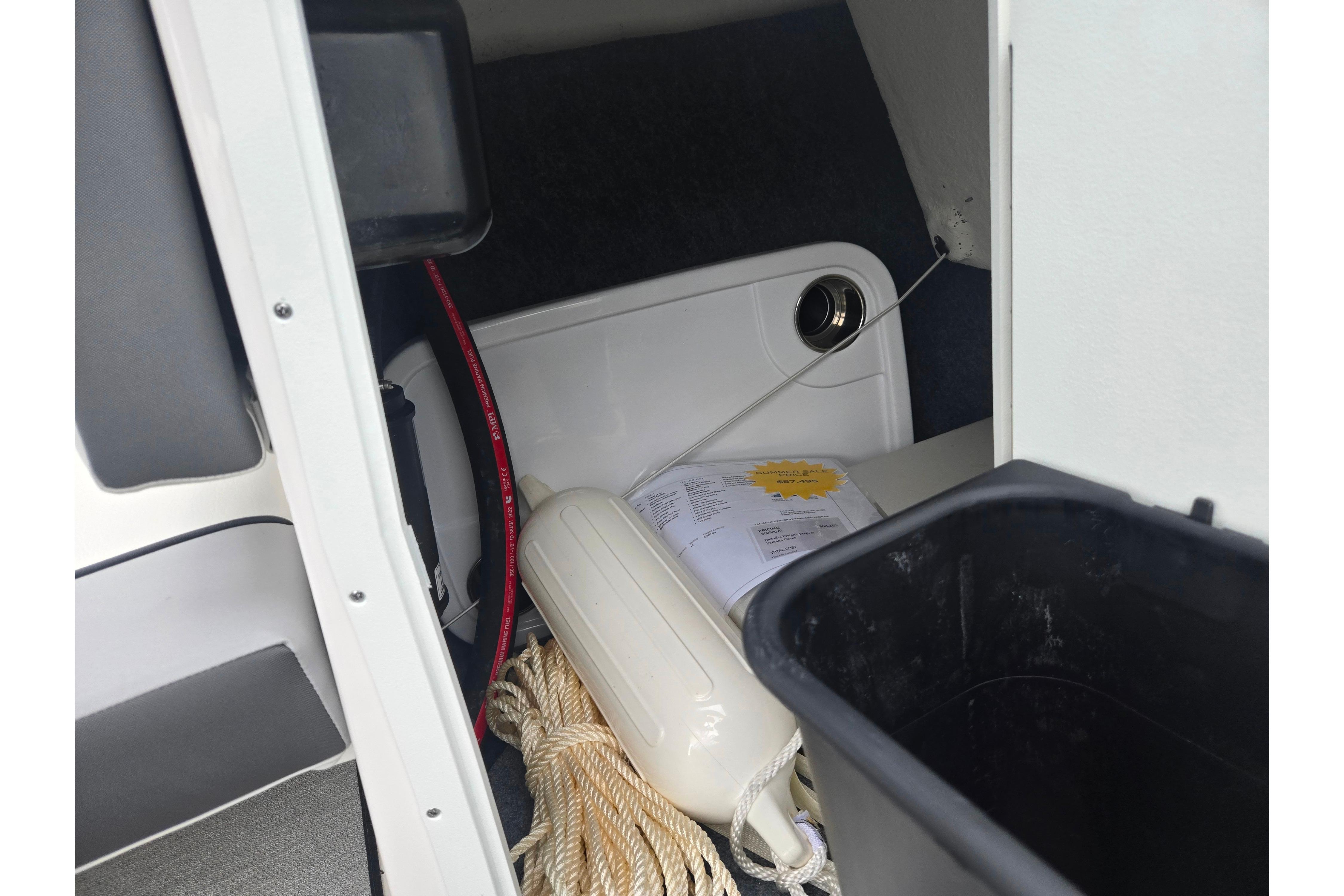 Storage compartment of 2024 Yamaha Boats AR220 with rope and fender.