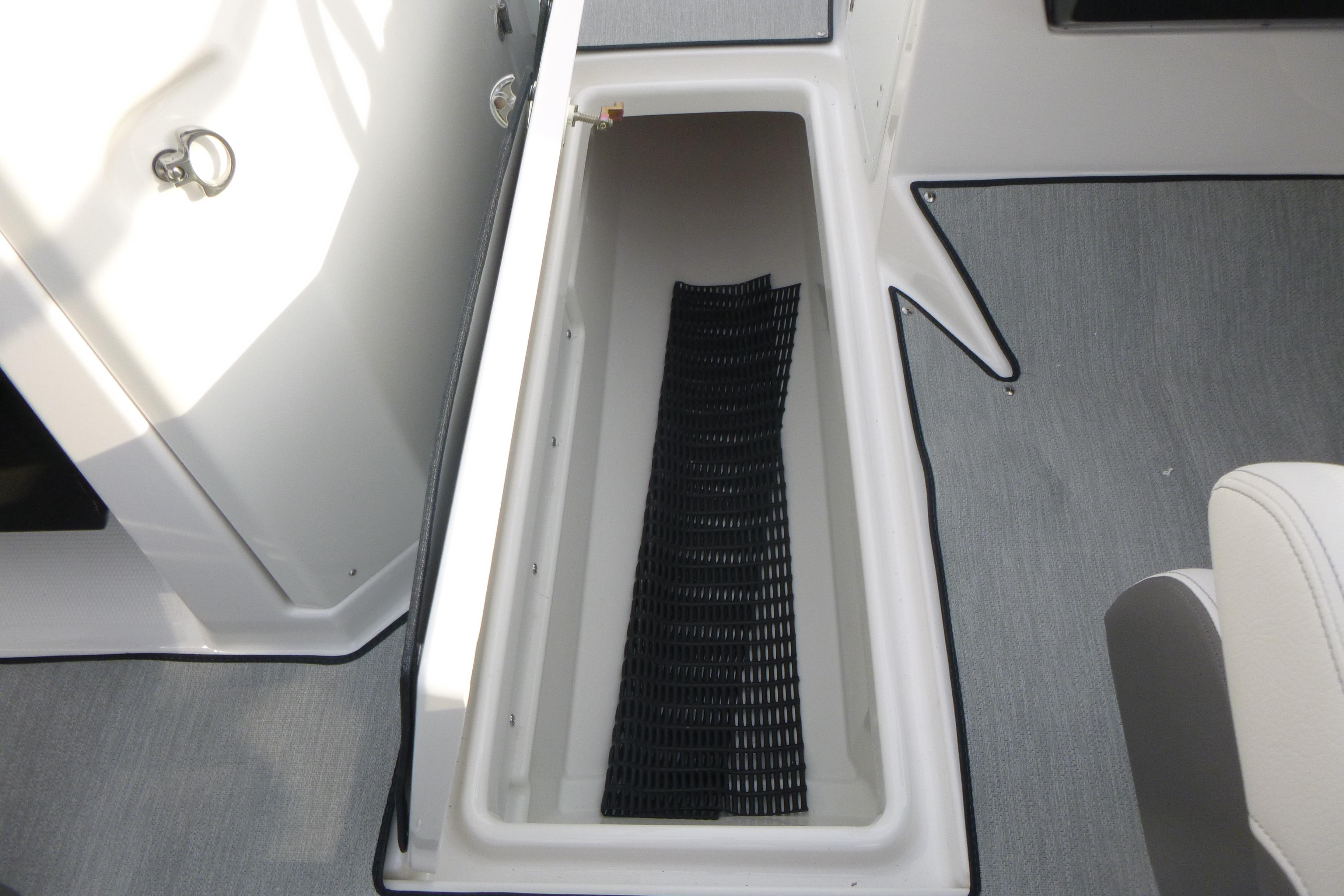 2026 Yamaha AR250 boat storage compartment with black mat, gray flooring.
