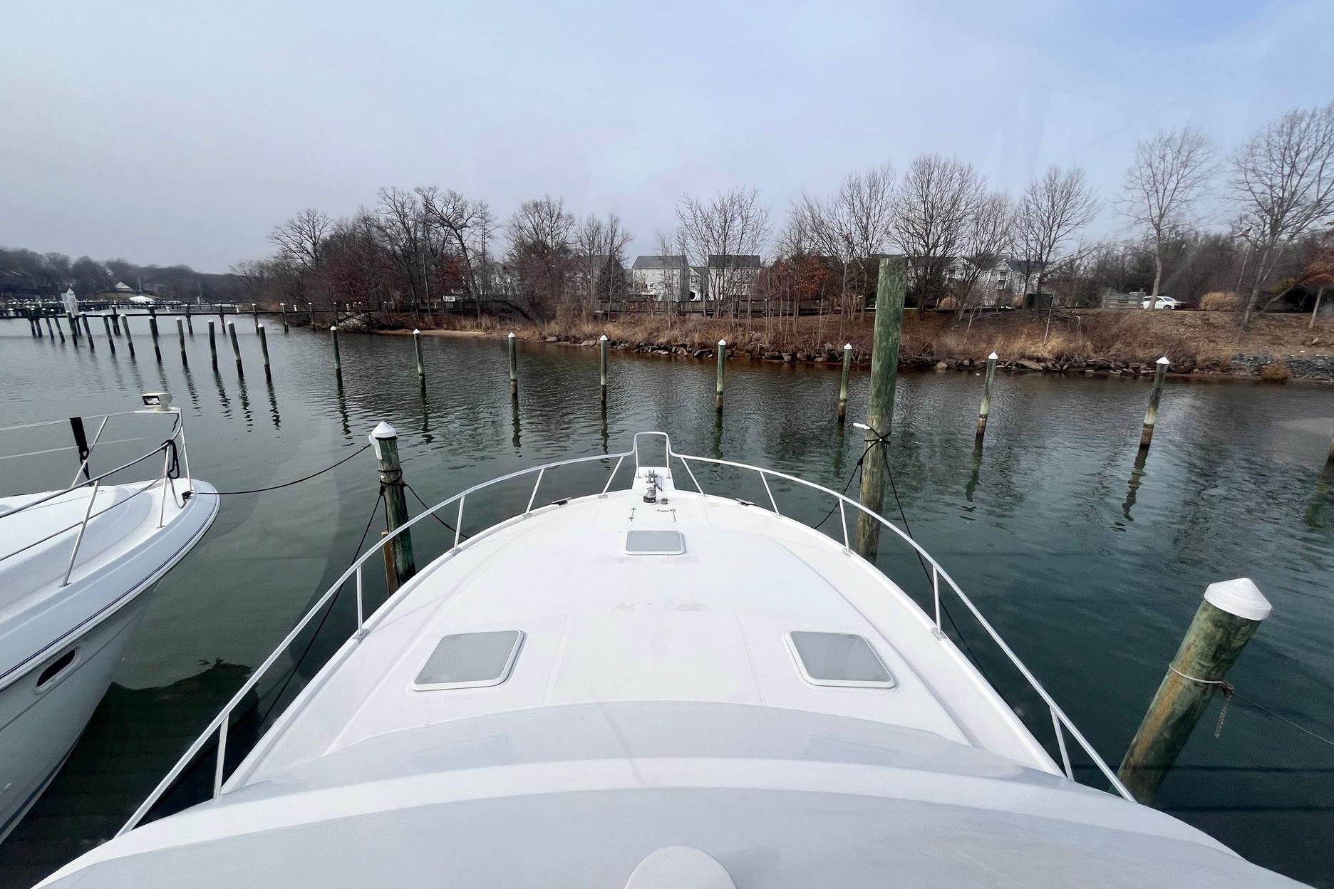 2003 Luhrs 40 Convertible yacht docked in a serene marina setting.