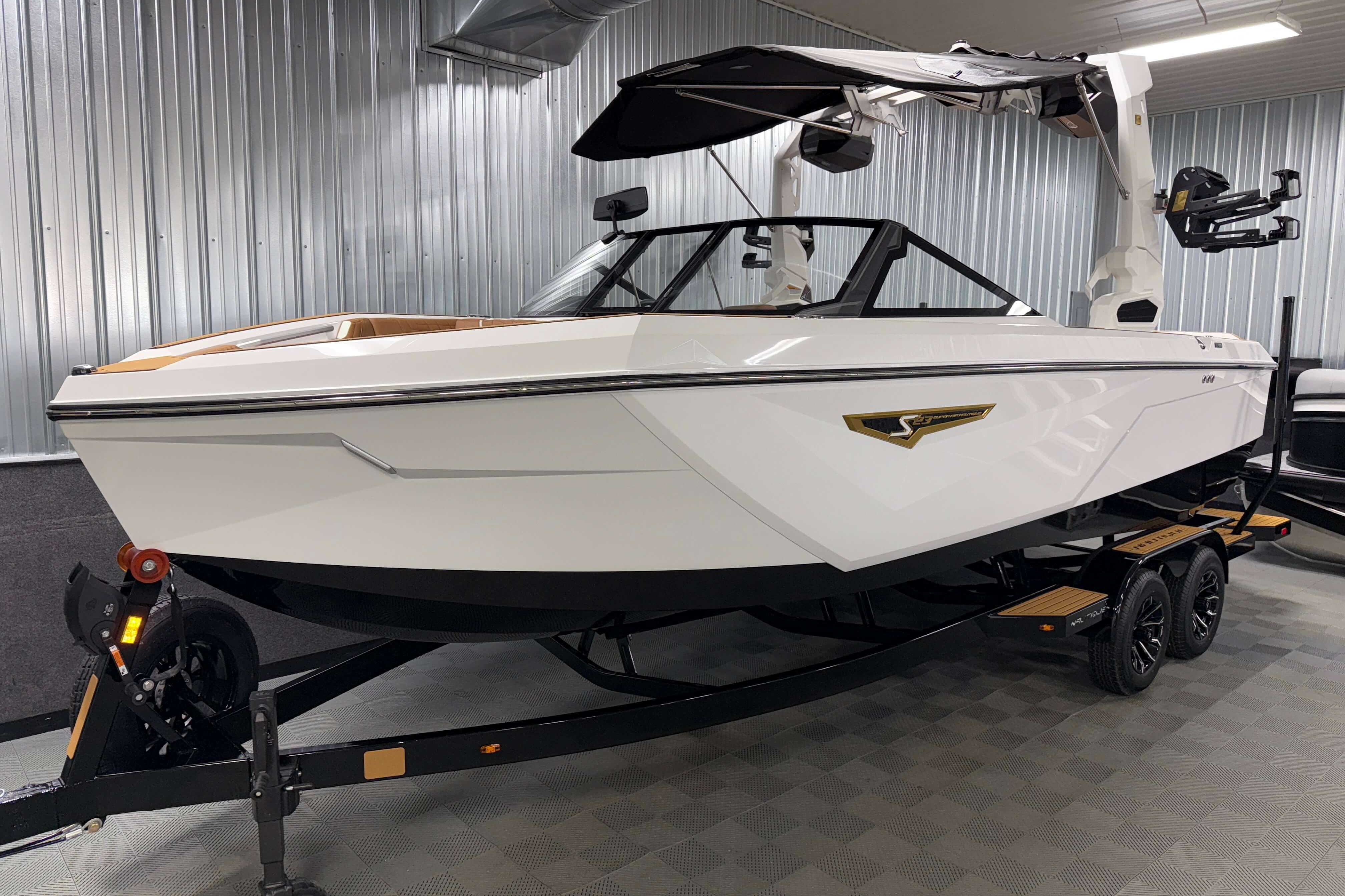 2026 Nautique Super Air Nautique S23 boat in showroom, sleek design, on trailer.