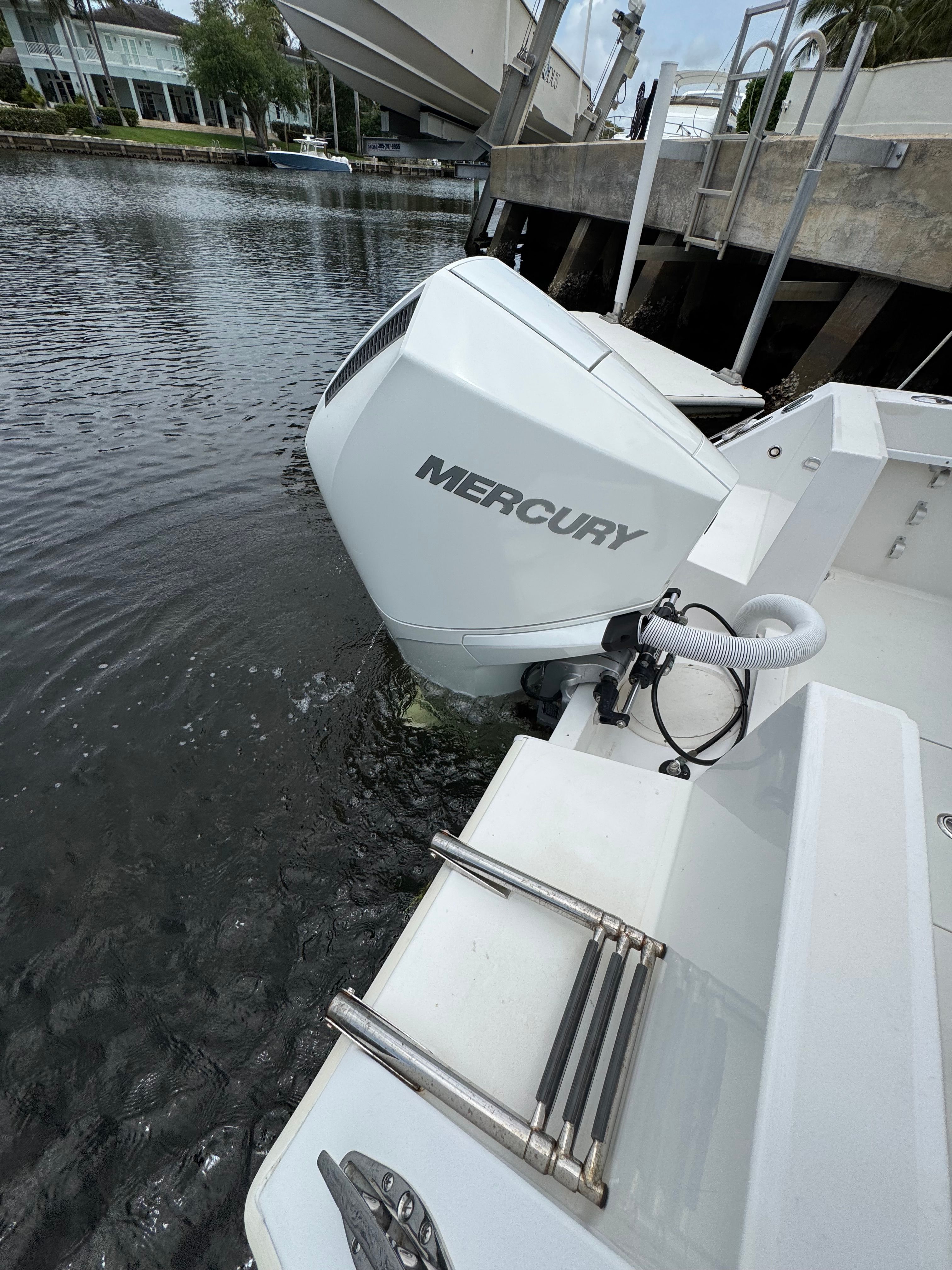 A Mercury outboard motor on a Contender 21 boat docked in the water.