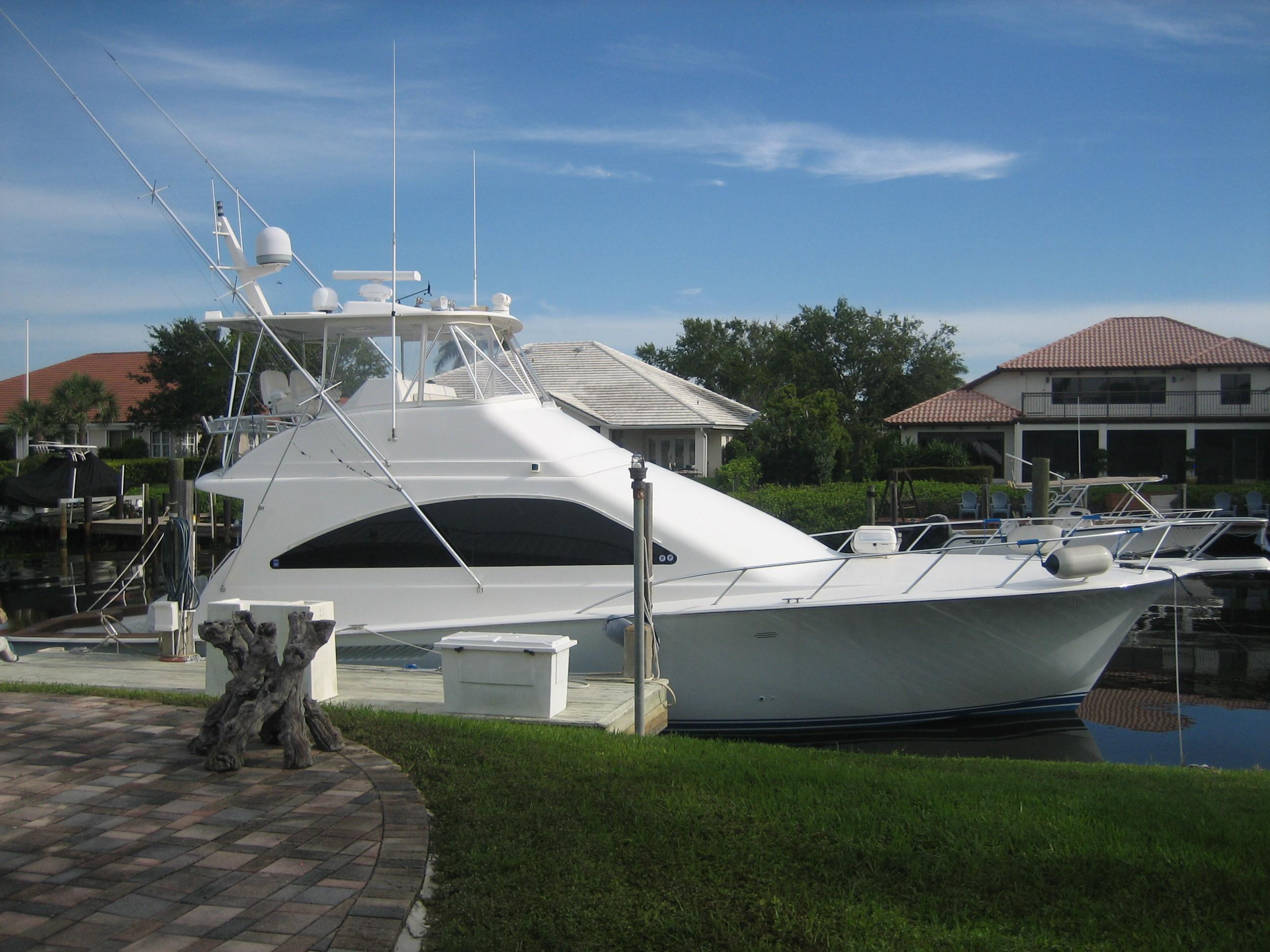 2005 Ocean Yachts 50 Super Sport docked near waterfront homes.