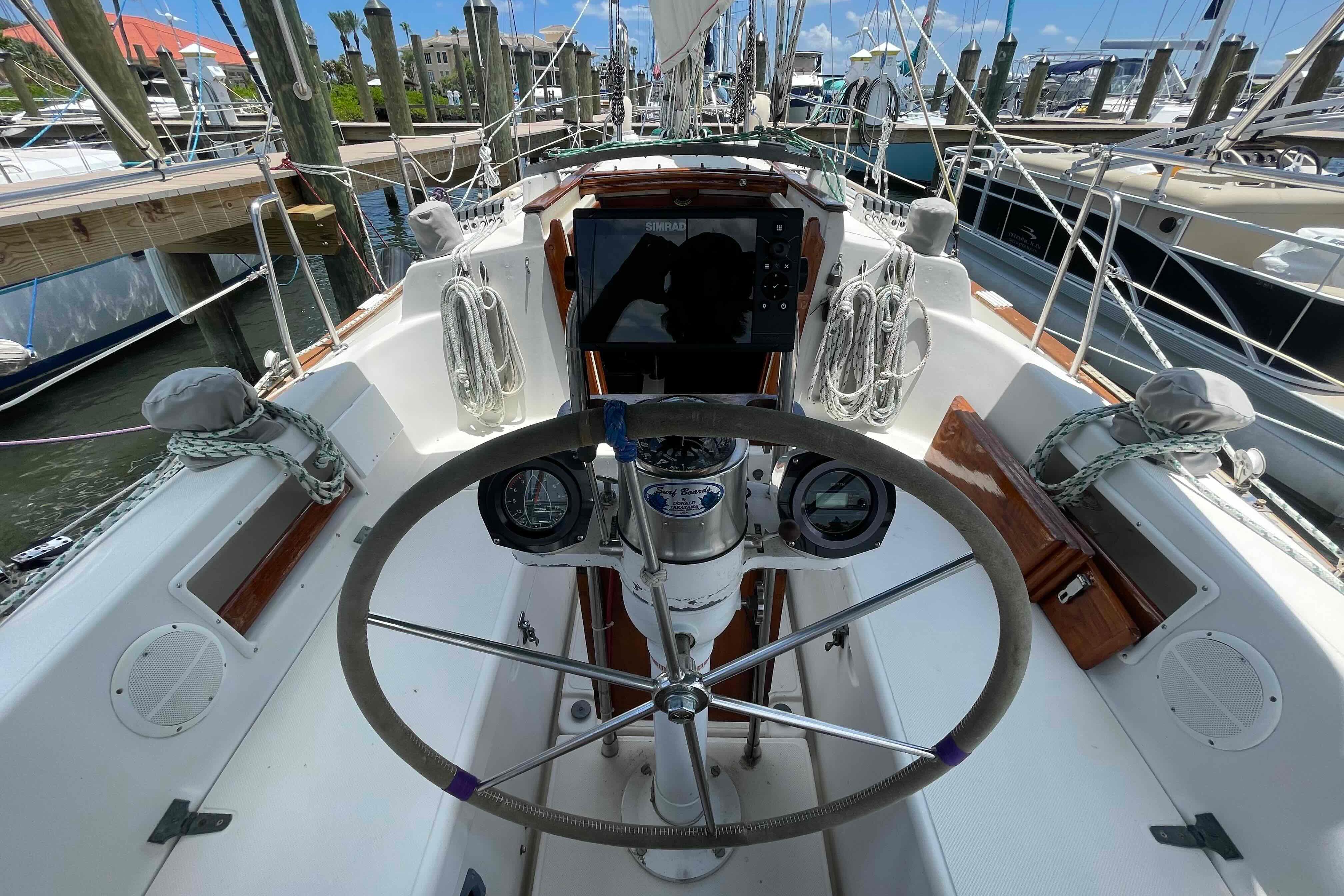 Cockpit of a 1987 Pacific Seacraft 34 sailboat with steering wheel and navigation instruments.