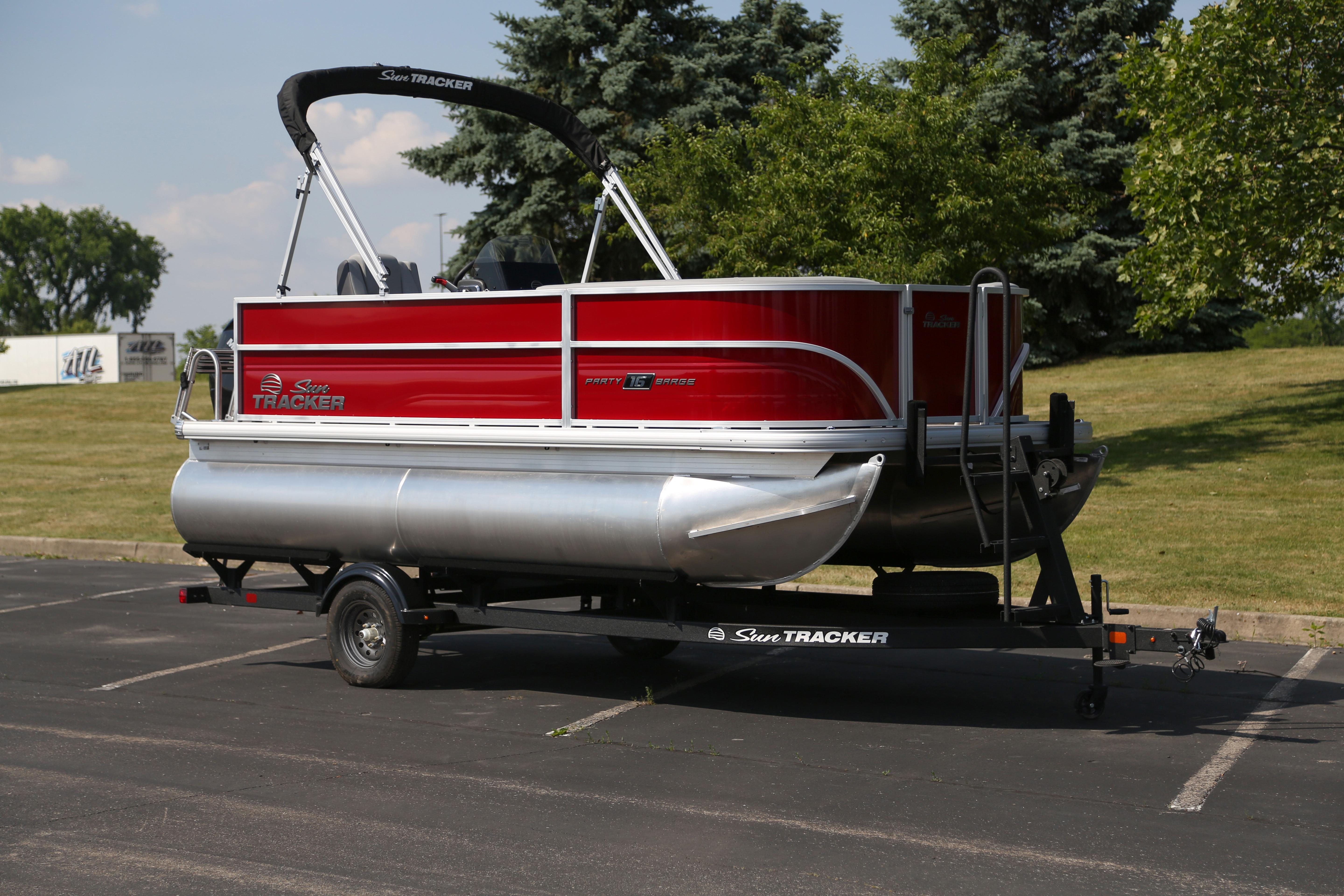 2026 Sun Tracker Party Barge 16 DLX pontoon boat on trailer, parked outdoors.