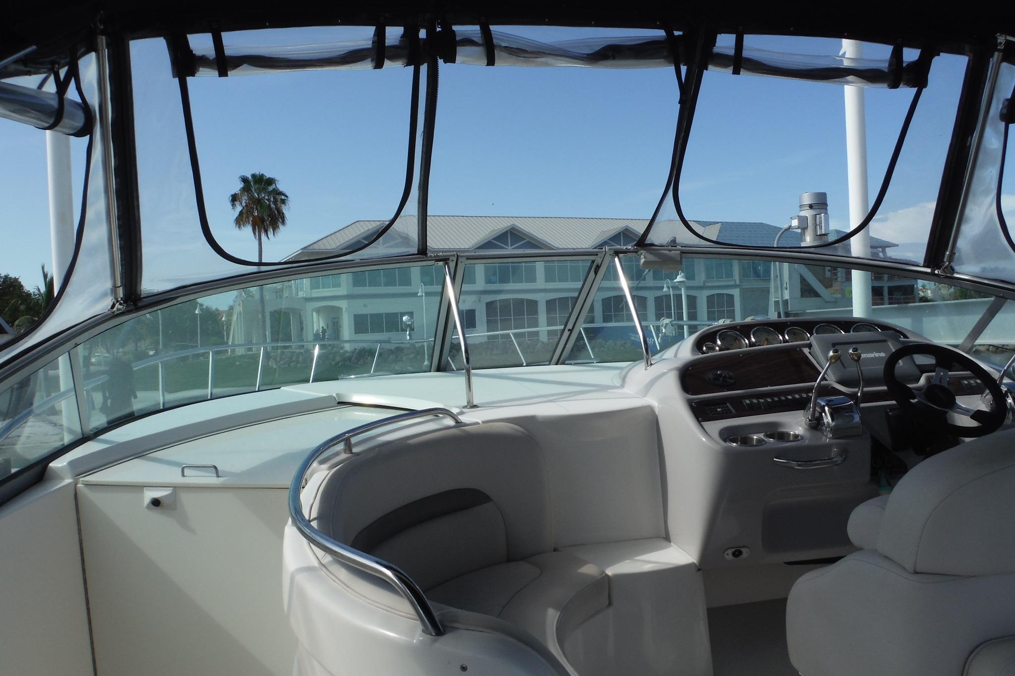 2005 Chaparral Signature 350 boat interior with helm and seating, overlooking waterfront buildings.