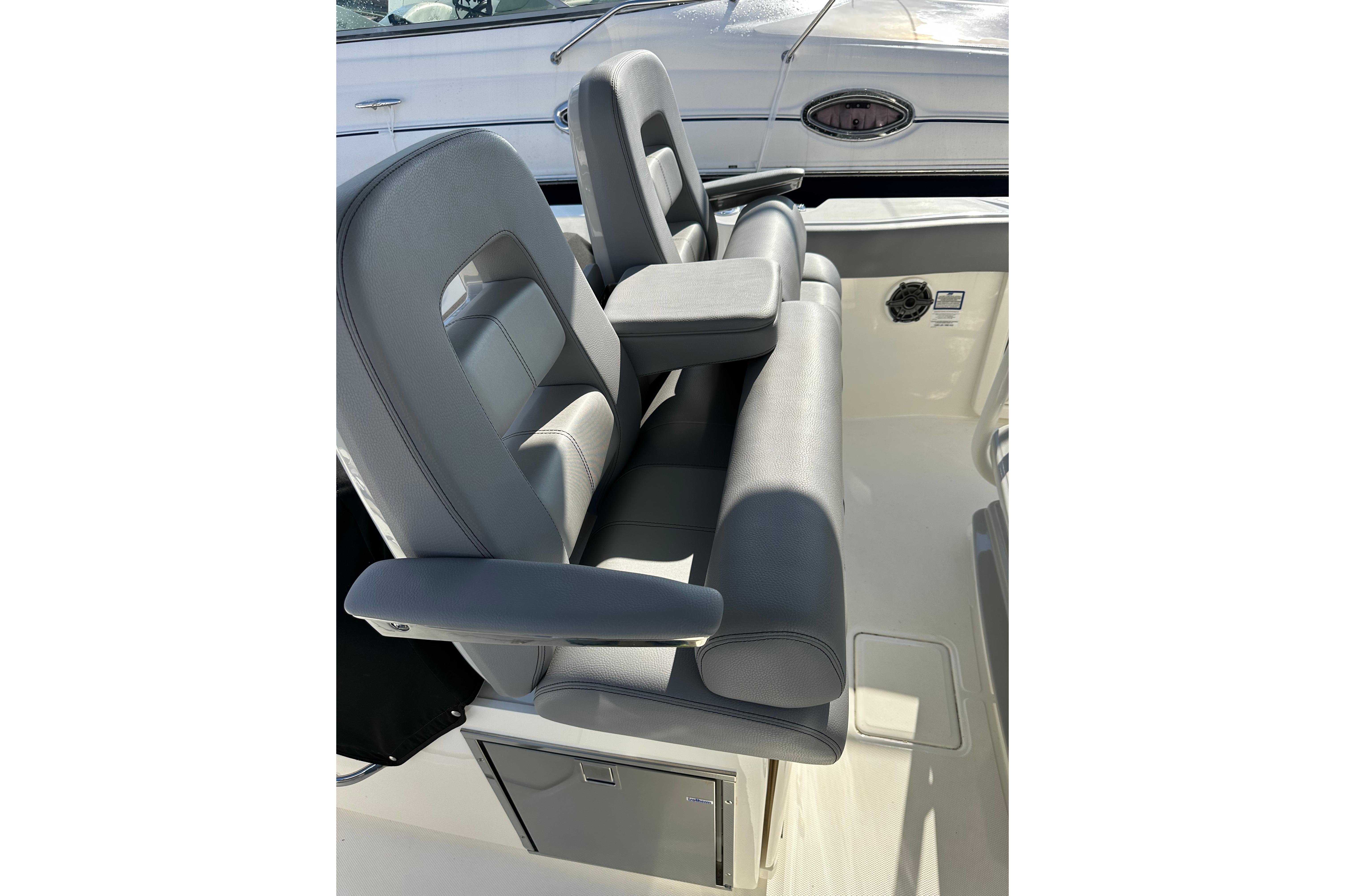 2023 Boston Whaler 330 Outrage boat seating with armrests and storage compartment.