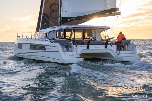 2025 Nautitech 48 Open catamaran sailing at sunset on open water.