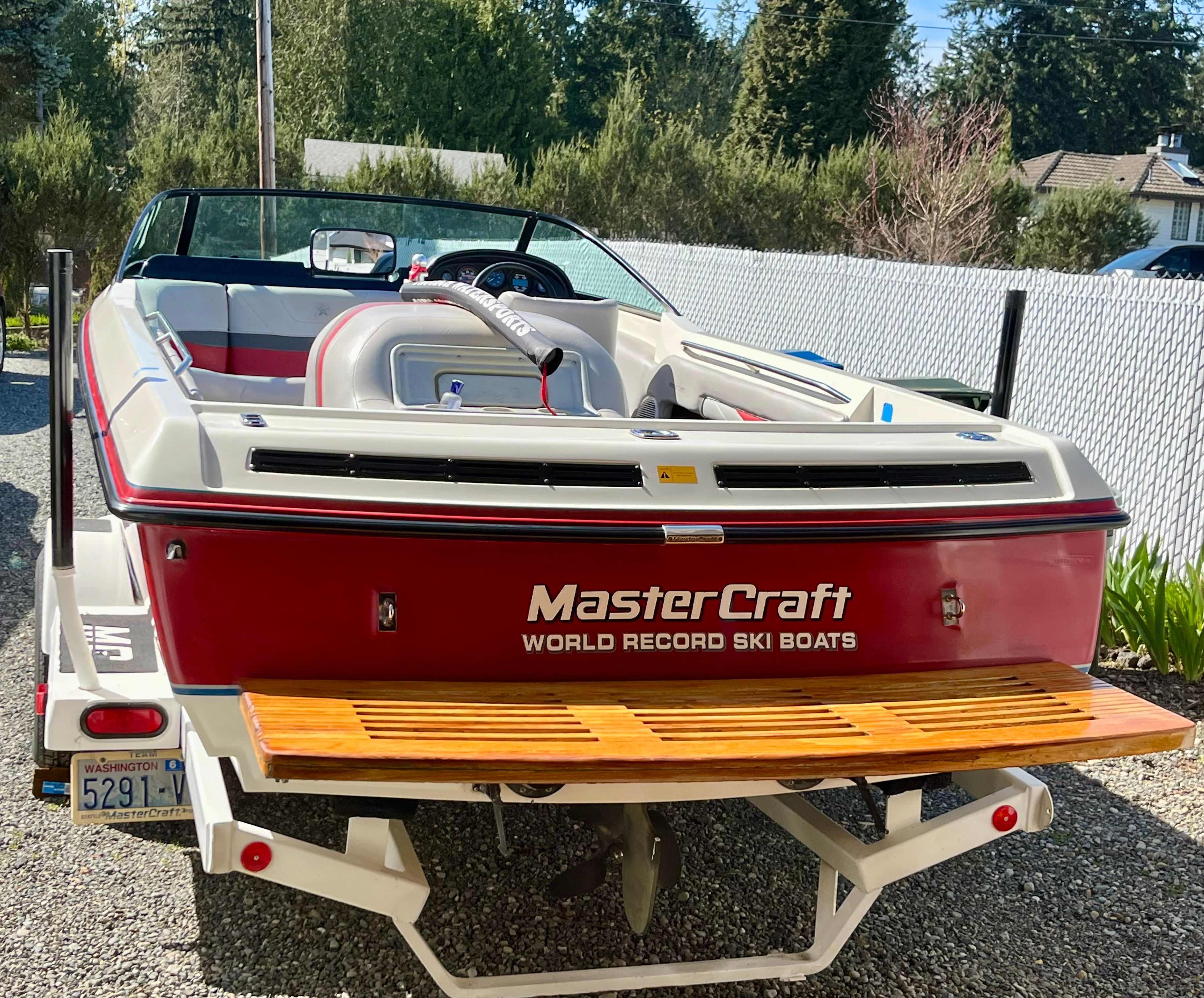 A 1992 MasterCraft ProStar on a trailer. It features a red stern and wooden elements.