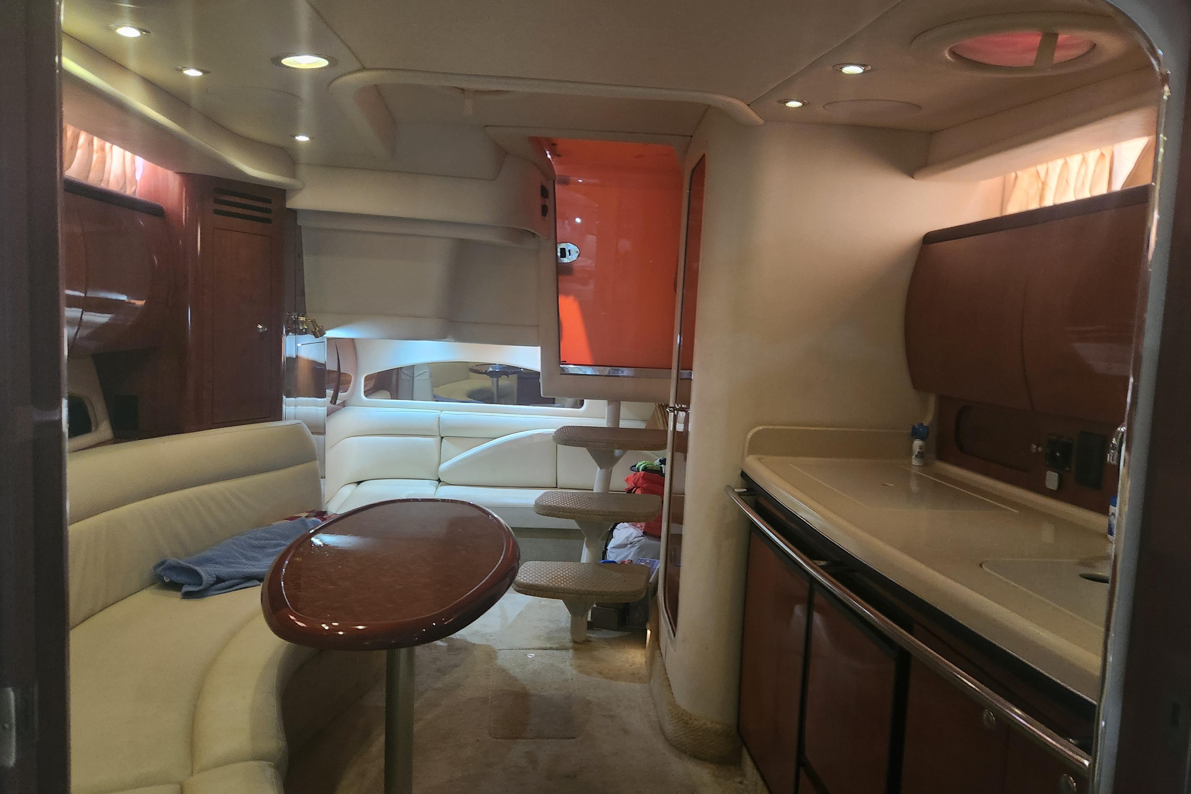 Interior of a 2003 Sea Ray 360 Sundancer yacht with elegant seating and kitchenette.
