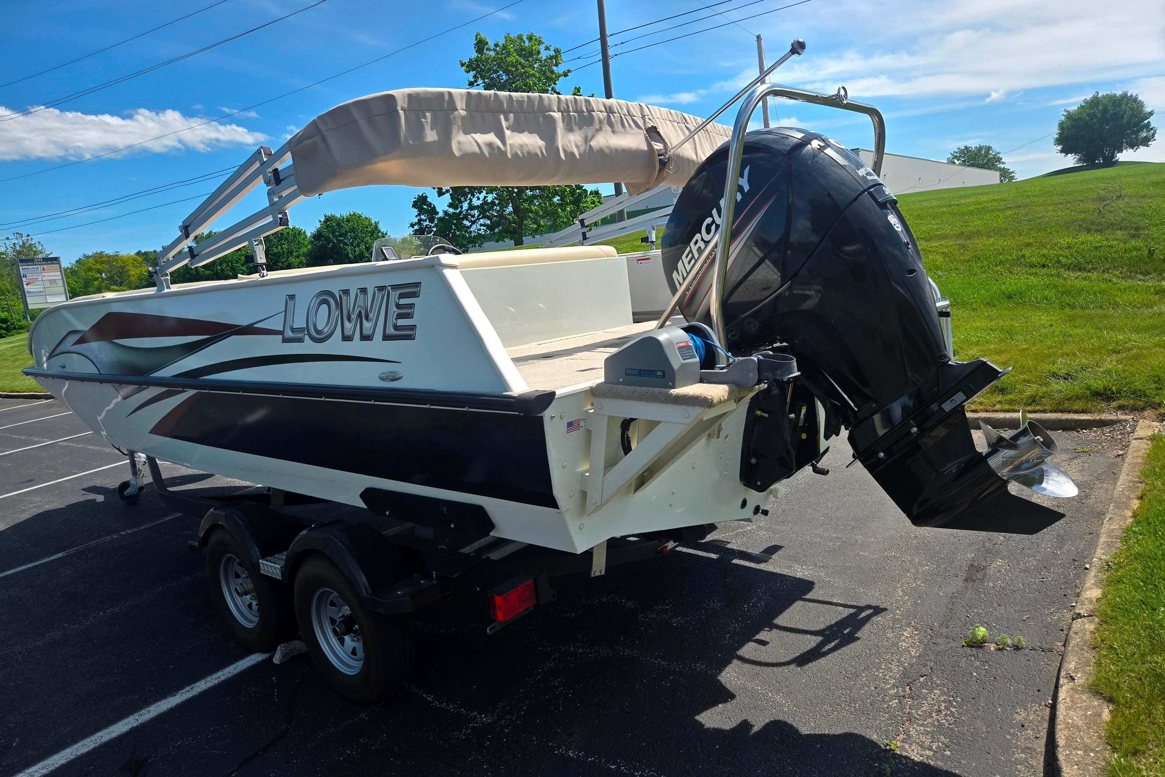 2015 Lowe Sport Deck 224 boat with Mercury outboard motor in a parking lot.