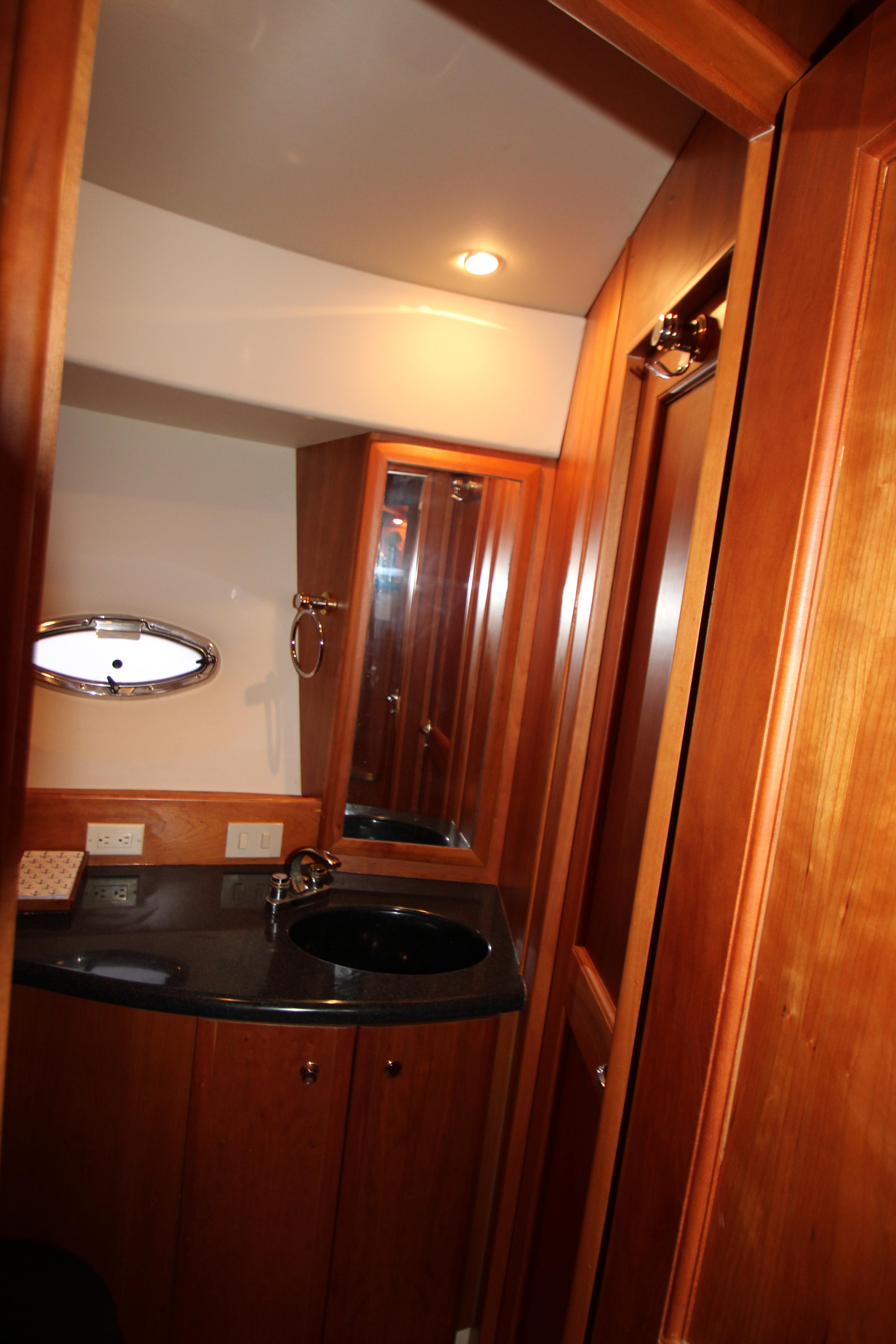 Luxurious bathroom in 2002 Silverton 43 Motor Yacht with wood cabinetry and modern fixtures.