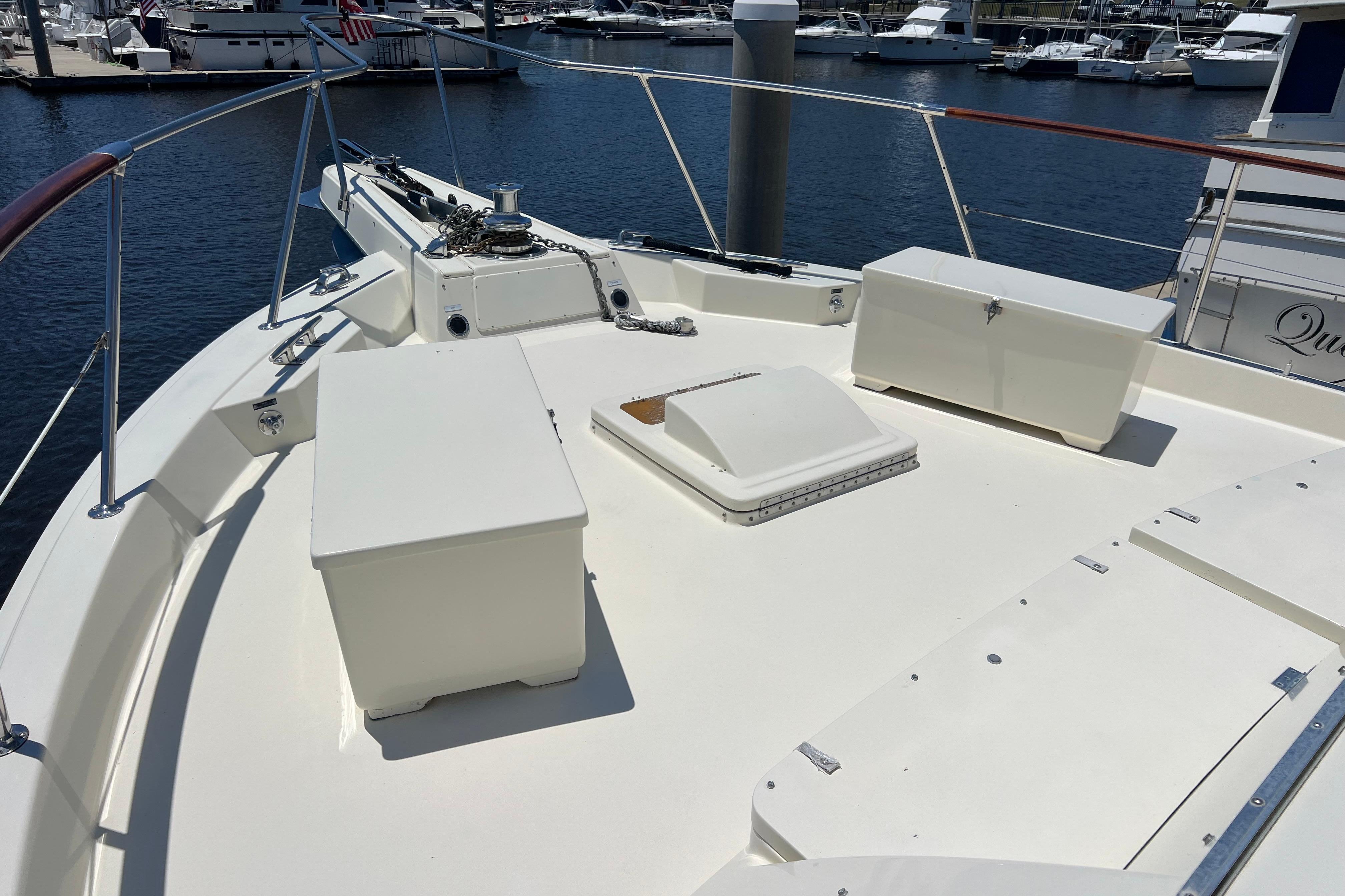 1987 Hatteras 70 Cockpit Motor Yacht deck with storage boxes, docked in marina.