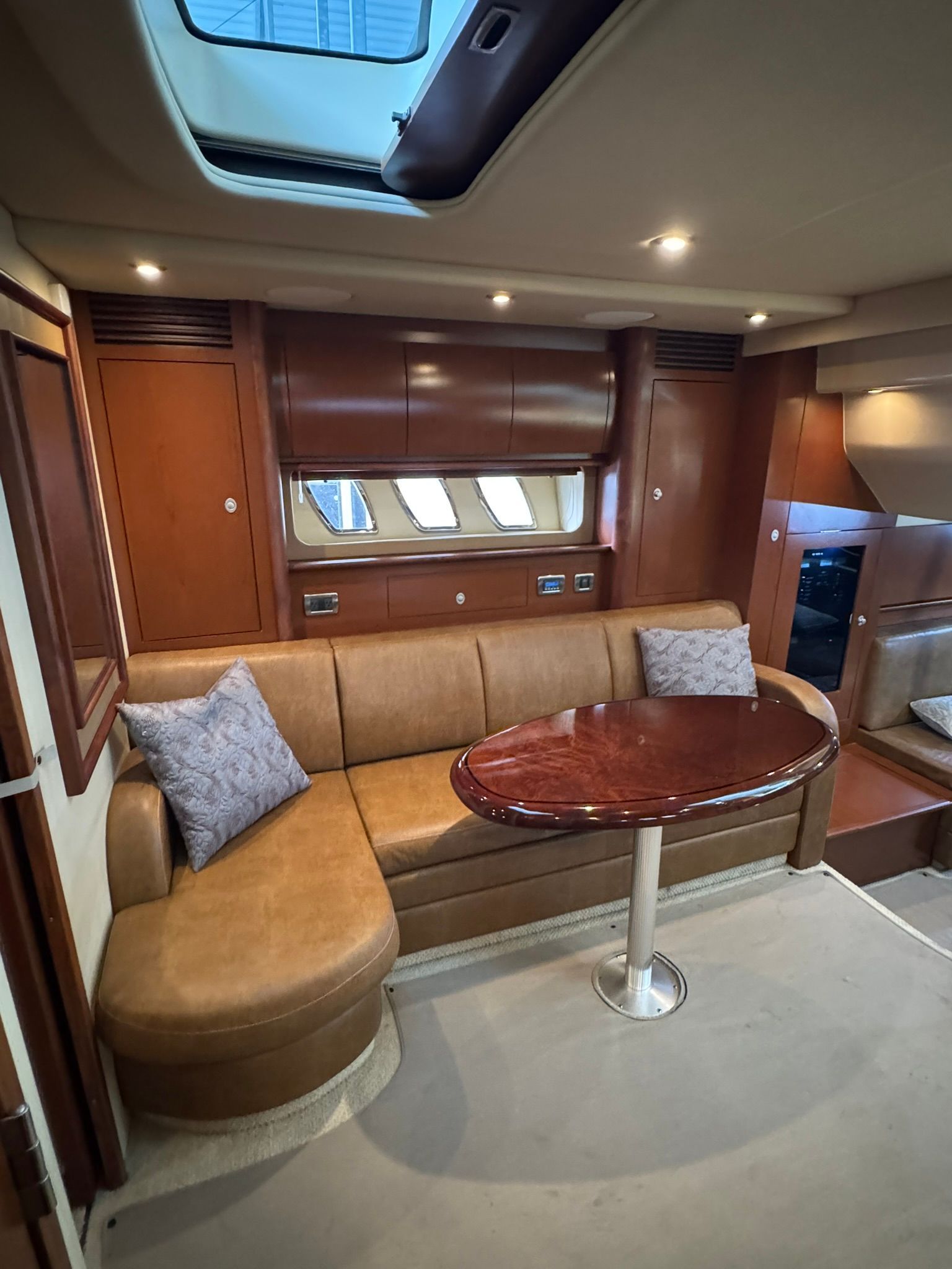 Interior of the 2007 Sea Ray 40 Sundancer with leather sofa and wooden table.