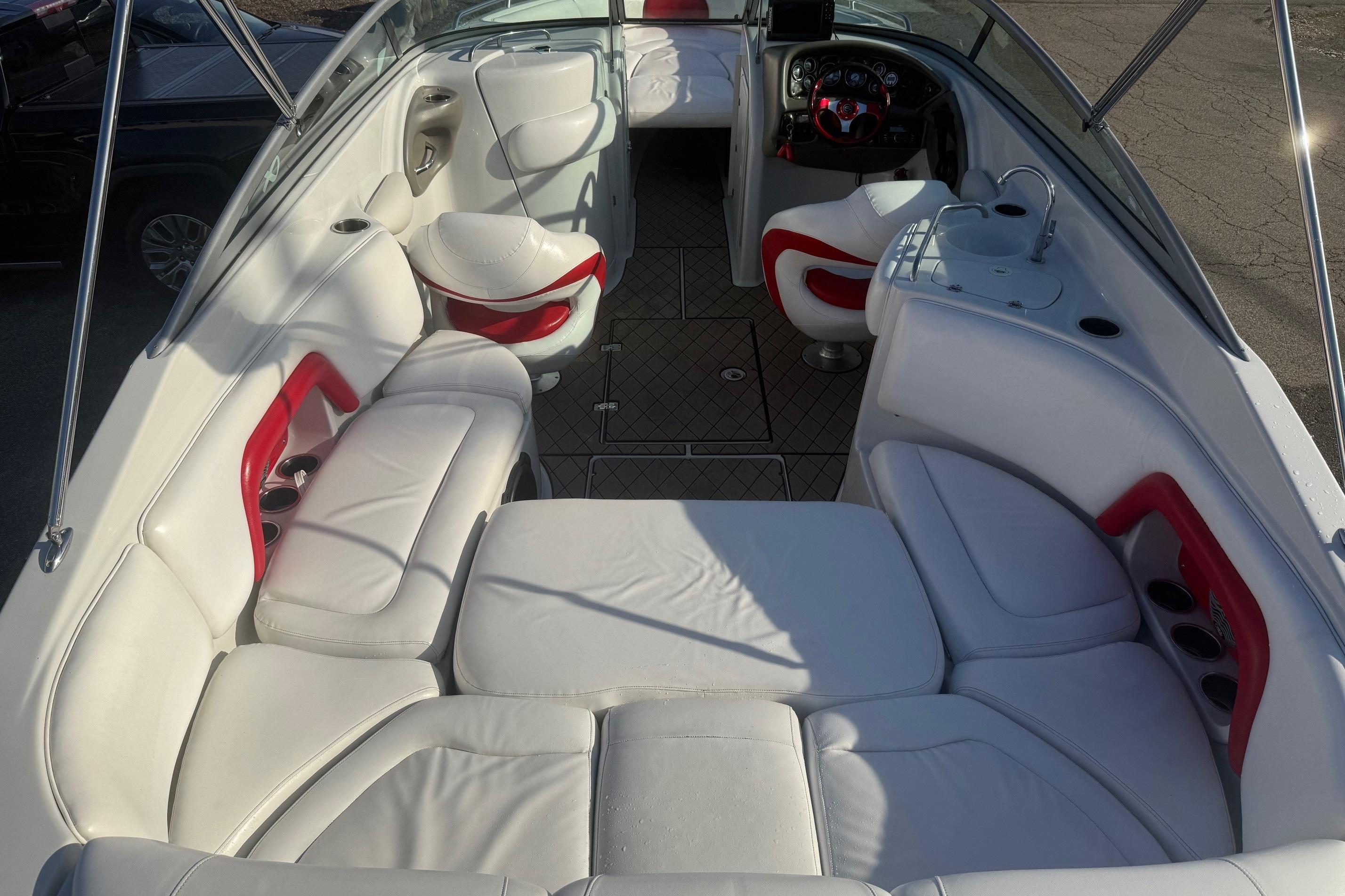 2005 Crownline 270 BR boat interior with white and red seating, steering console, and cup holders.
