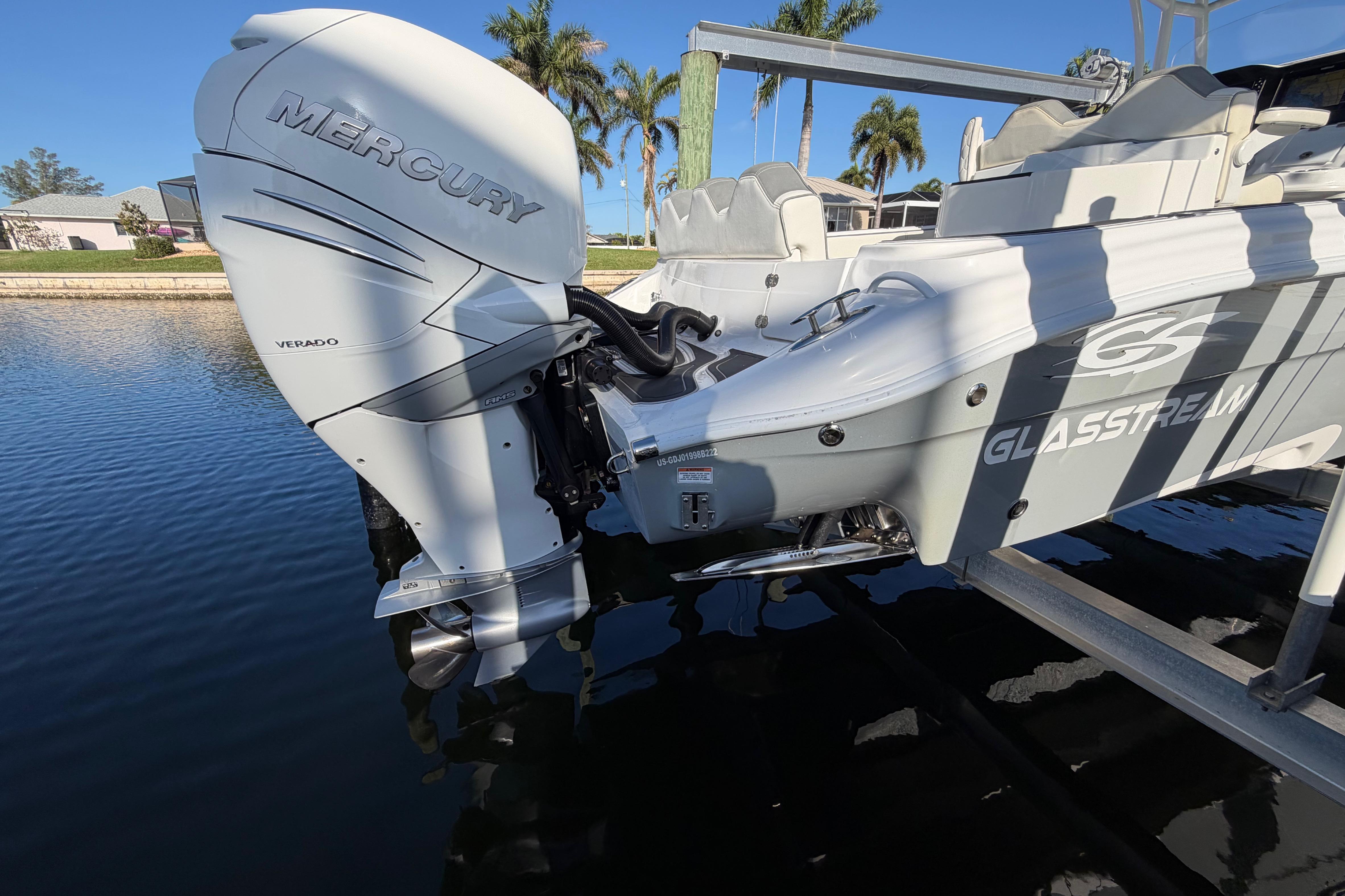2022 Glasstream 328 Pro-XS boat with Mercury Verado engine, docked by palm trees.