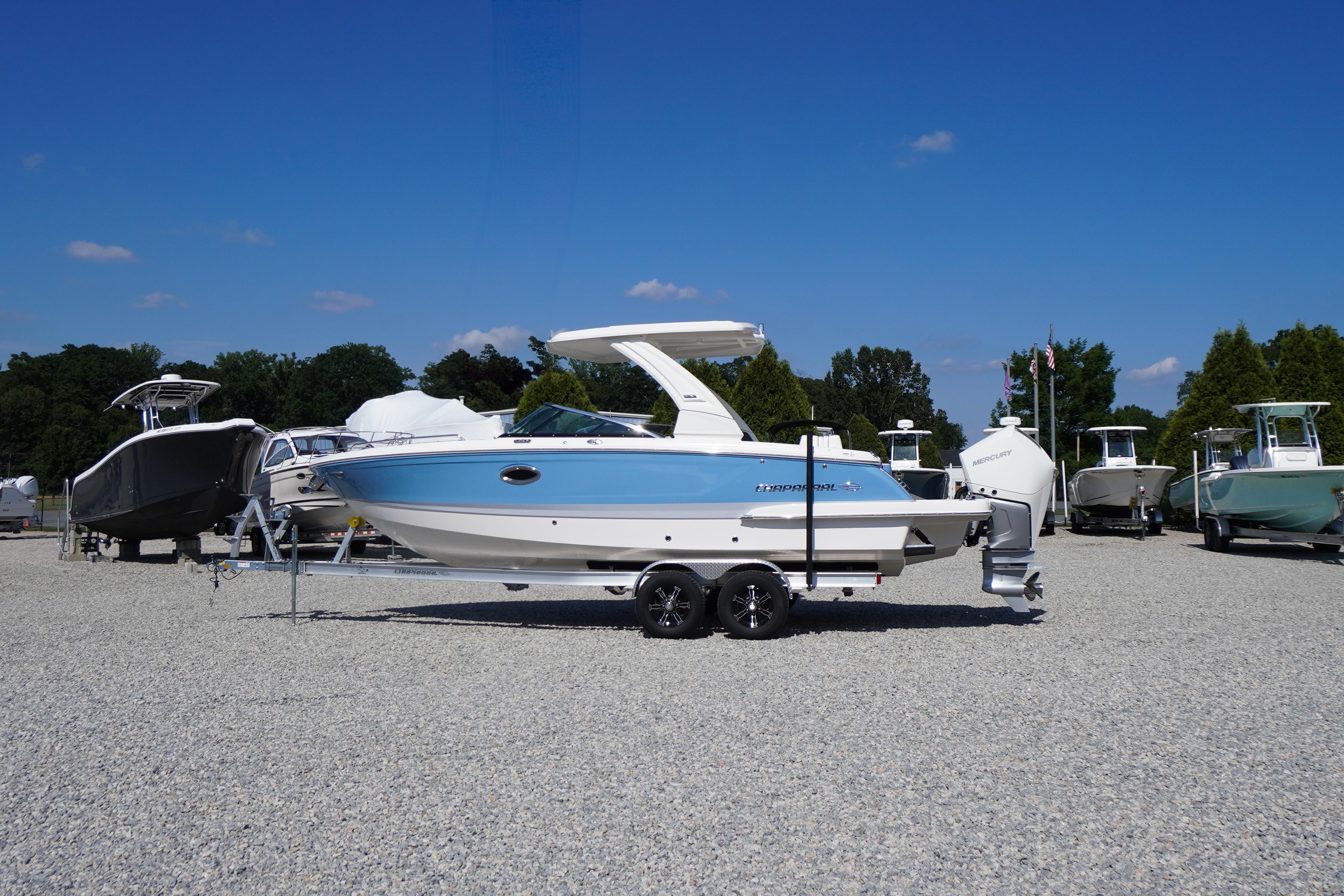 2026 Chaparral 270 OSX boat on trailer, displayed outdoors under clear blue sky.