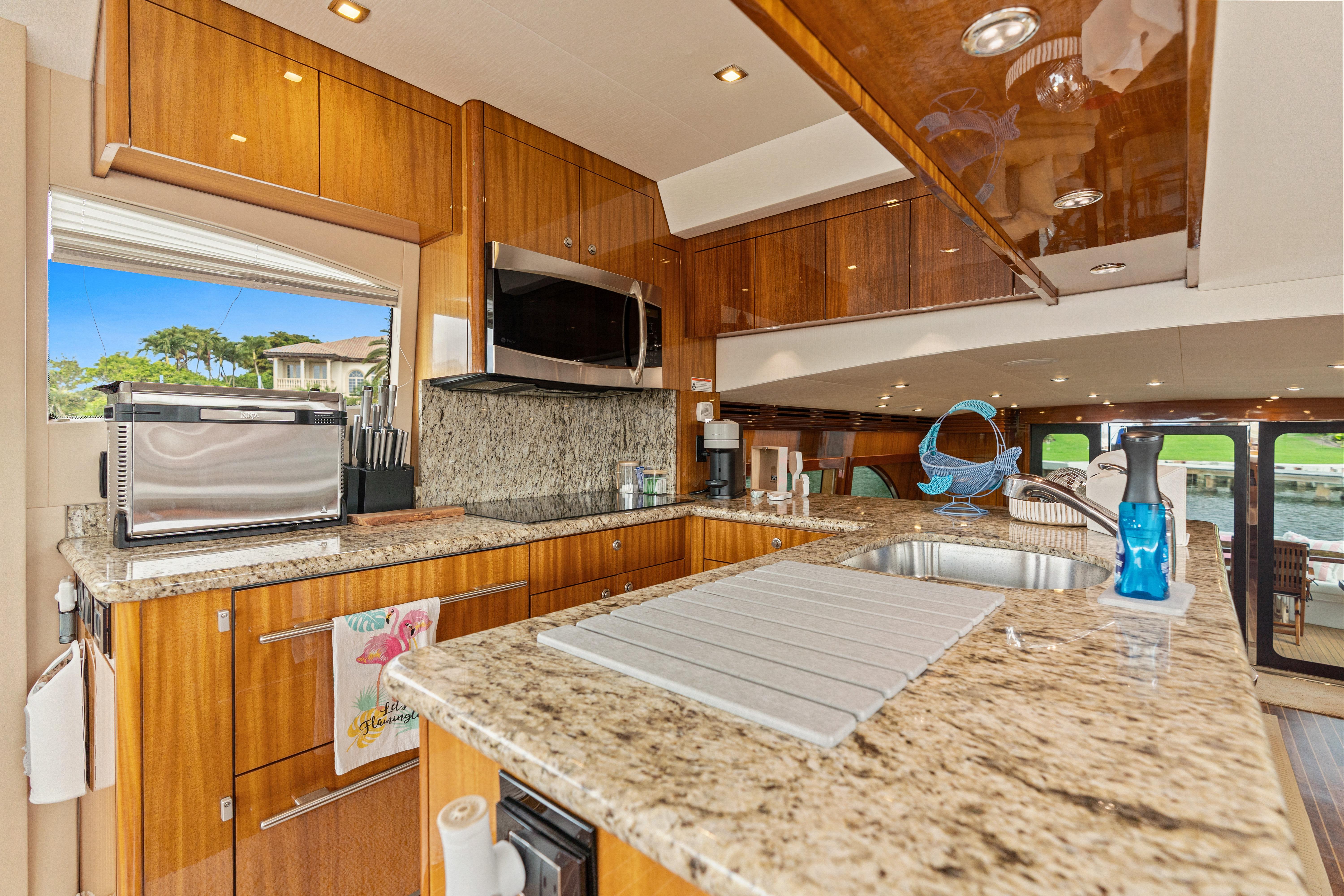 Luxurious kitchen interior of 2008 Hatteras 64 Motor Yacht with granite countertops.