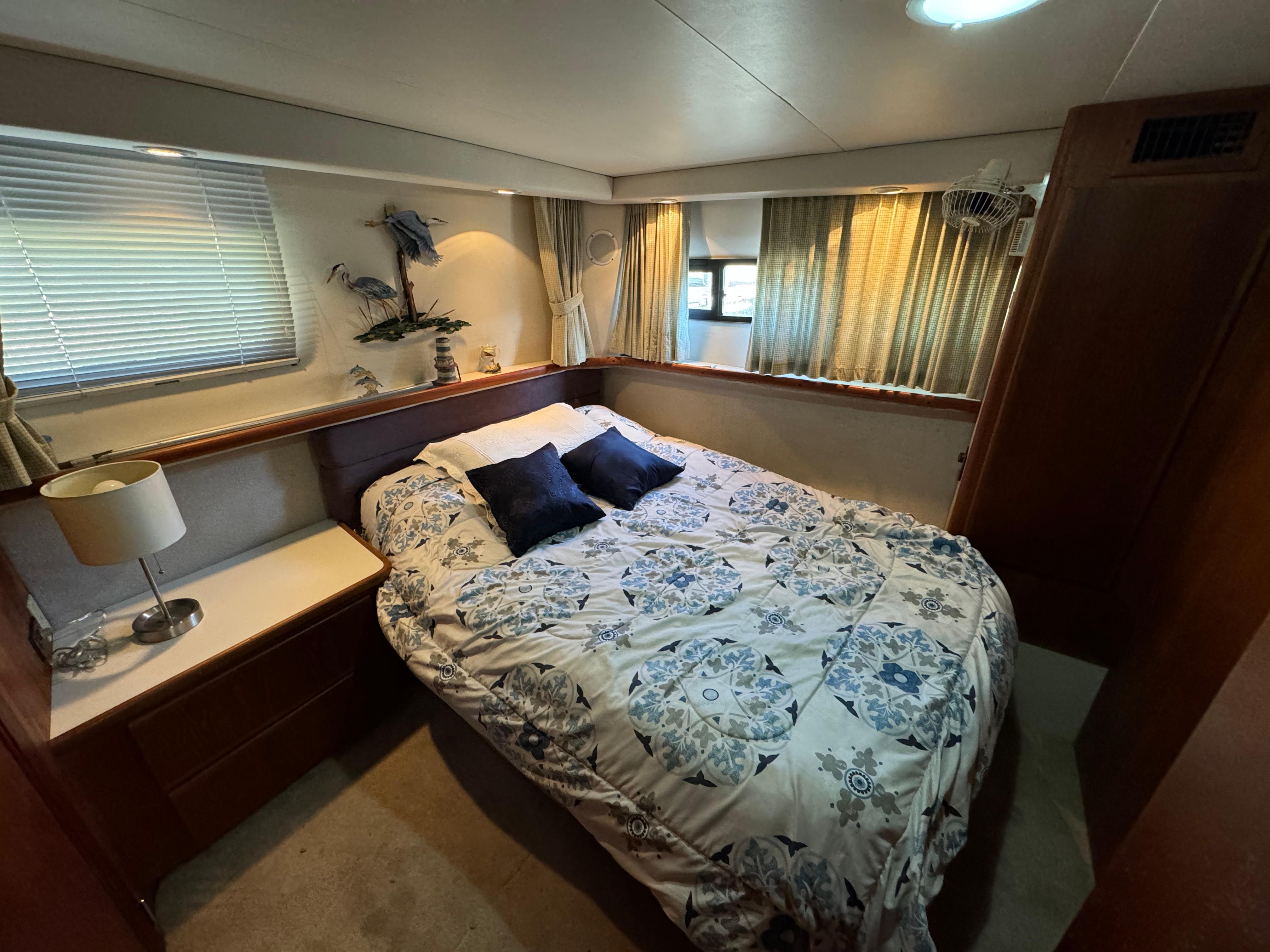 1991 Carver 33 Aft Cabin bedroom with cozy bed, decorative pillows, and nautical decor.