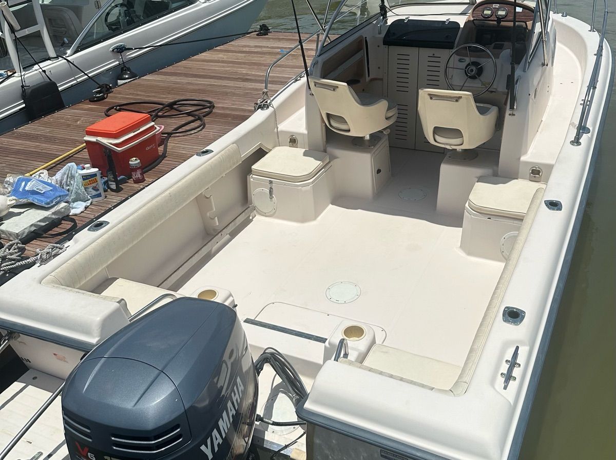 A 1998 Grady-White Adventure 208 docked. It features a Yamaha outboard motor.