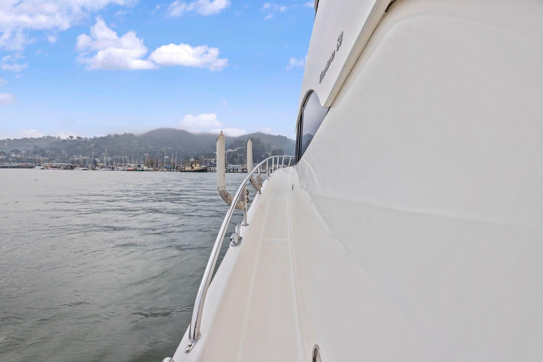 Side view of a 2014 Maritimo M50 yacht on calm waters under a blue sky.