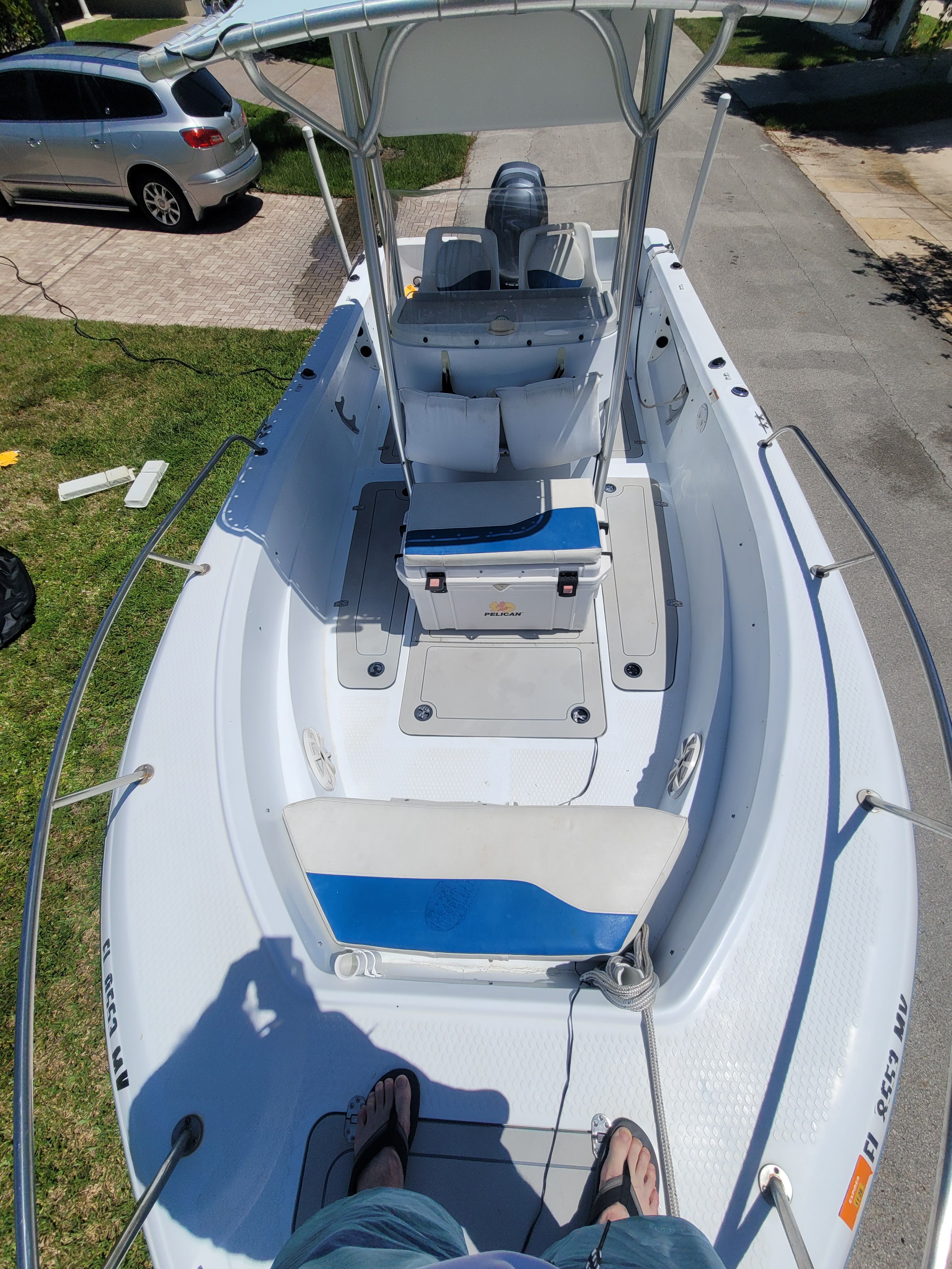 A white boat with blue accents, featuring a helm station and seating area.