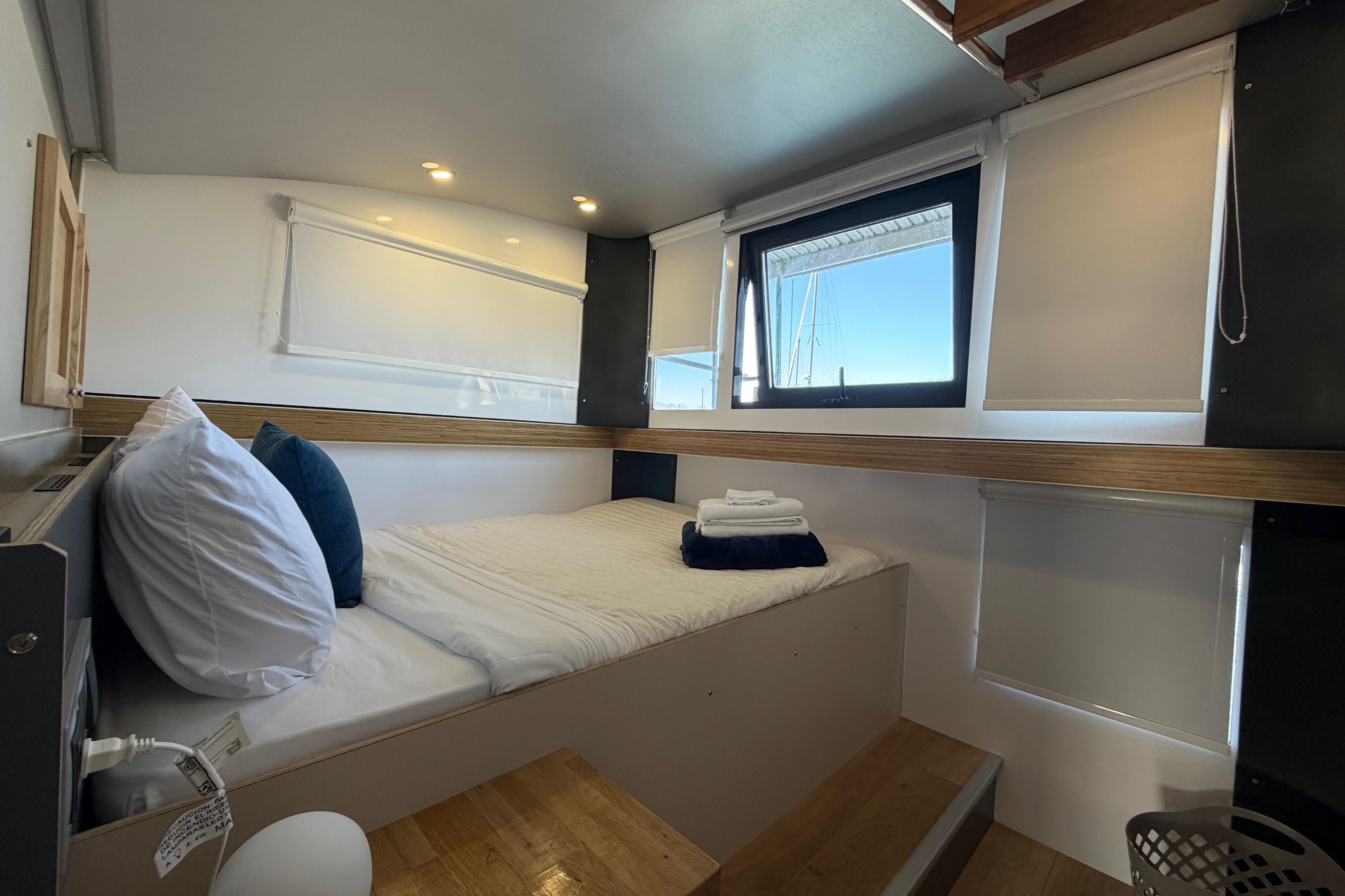 Cozy interior of 2022 Navisyo NV.08 with bed, pillows, and window view.
