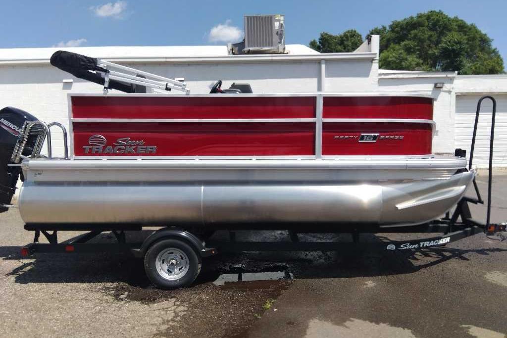 2026 Sun Tracker Party Barge 16 DLX pontoon boat on trailer, red and silver design.