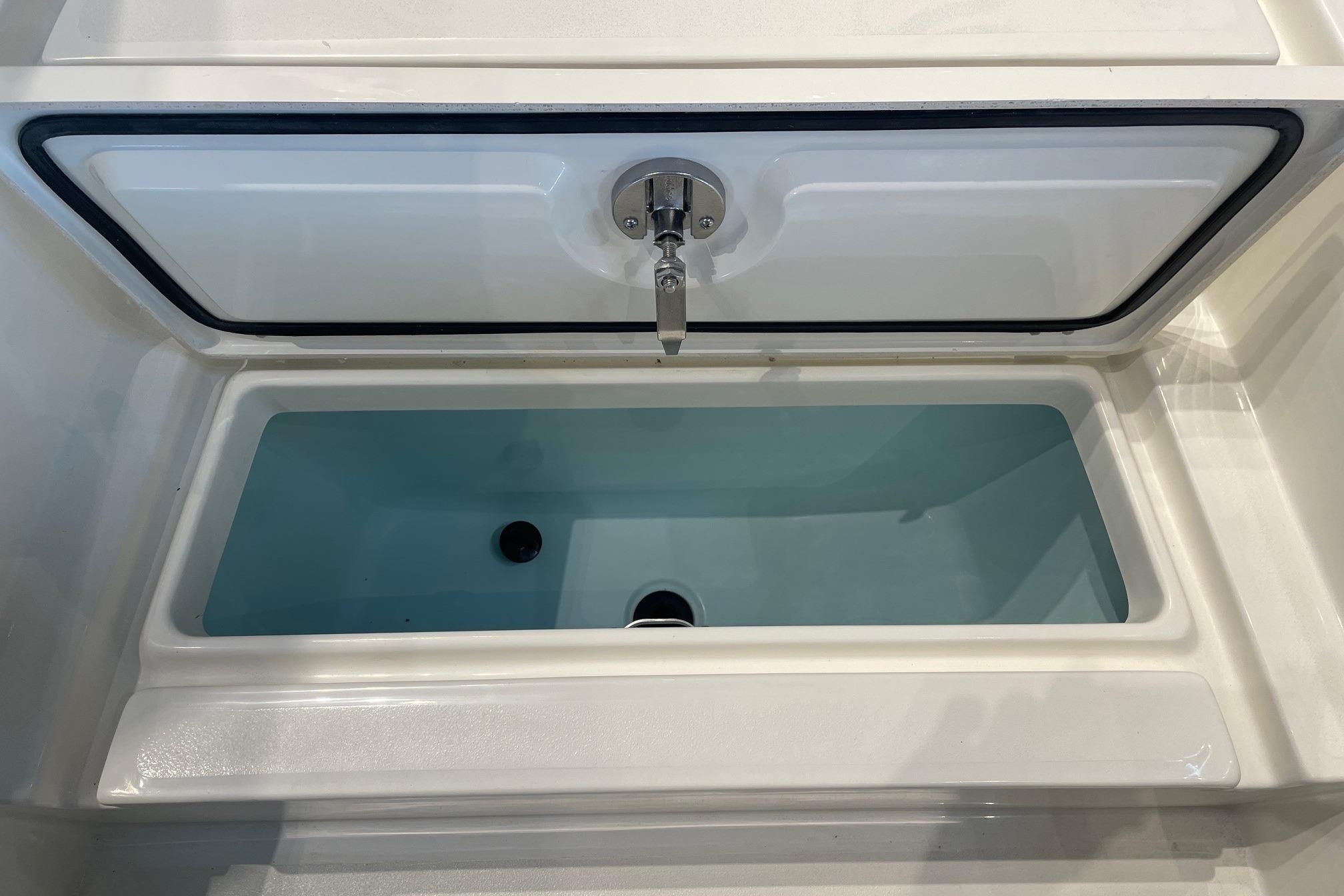 Open storage compartment on 2026 Mako 24 APEX boat, featuring a clean, spacious interior.