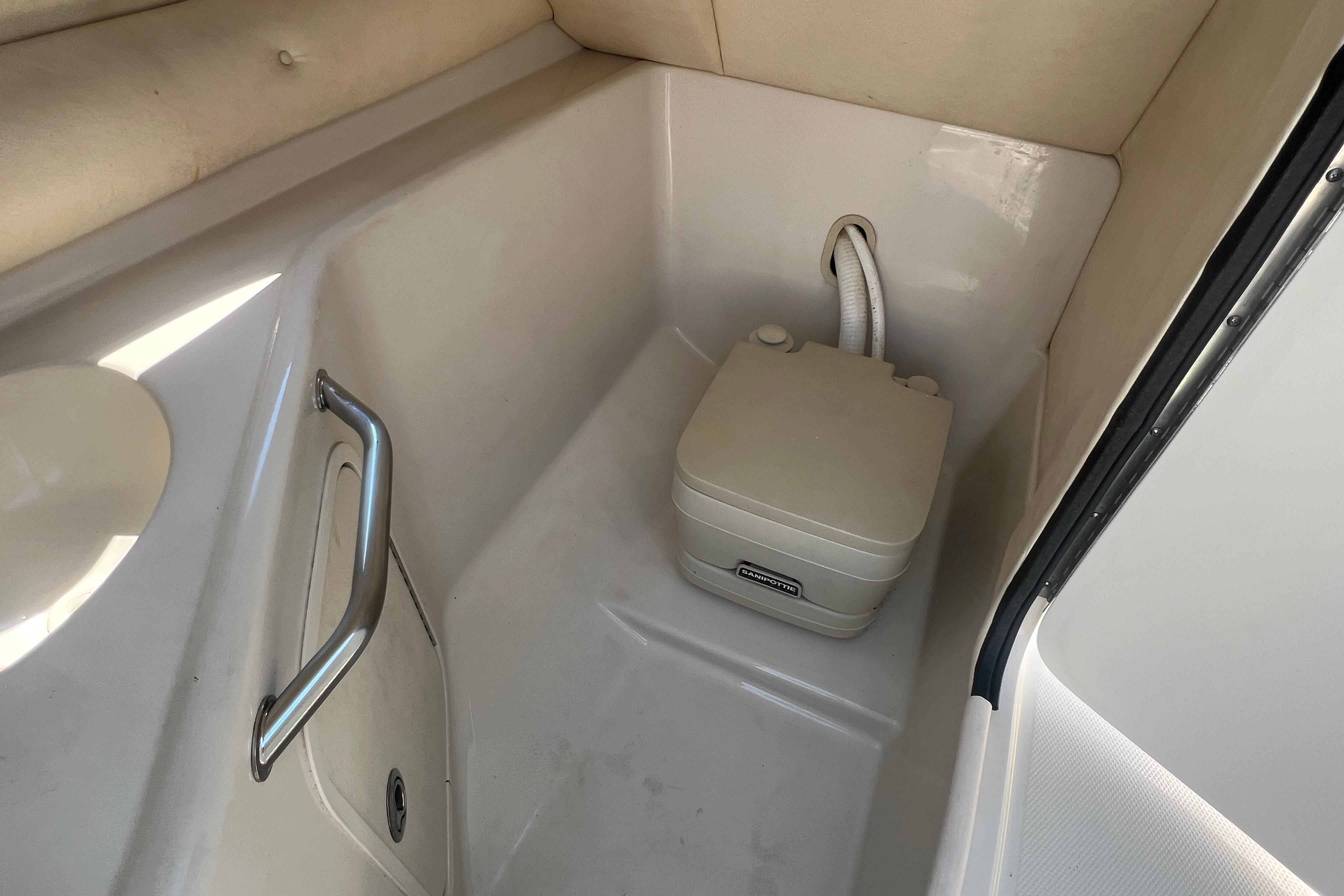 Portable toilet inside 2005 Sea Ray 240 Sundeck boat cabin.