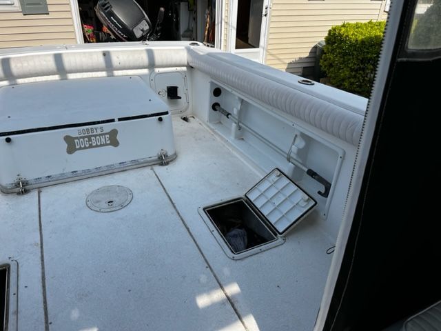 The image shows the deck of a 1998 Sport-Craft 252 Sport Fish boat with storage compartments.