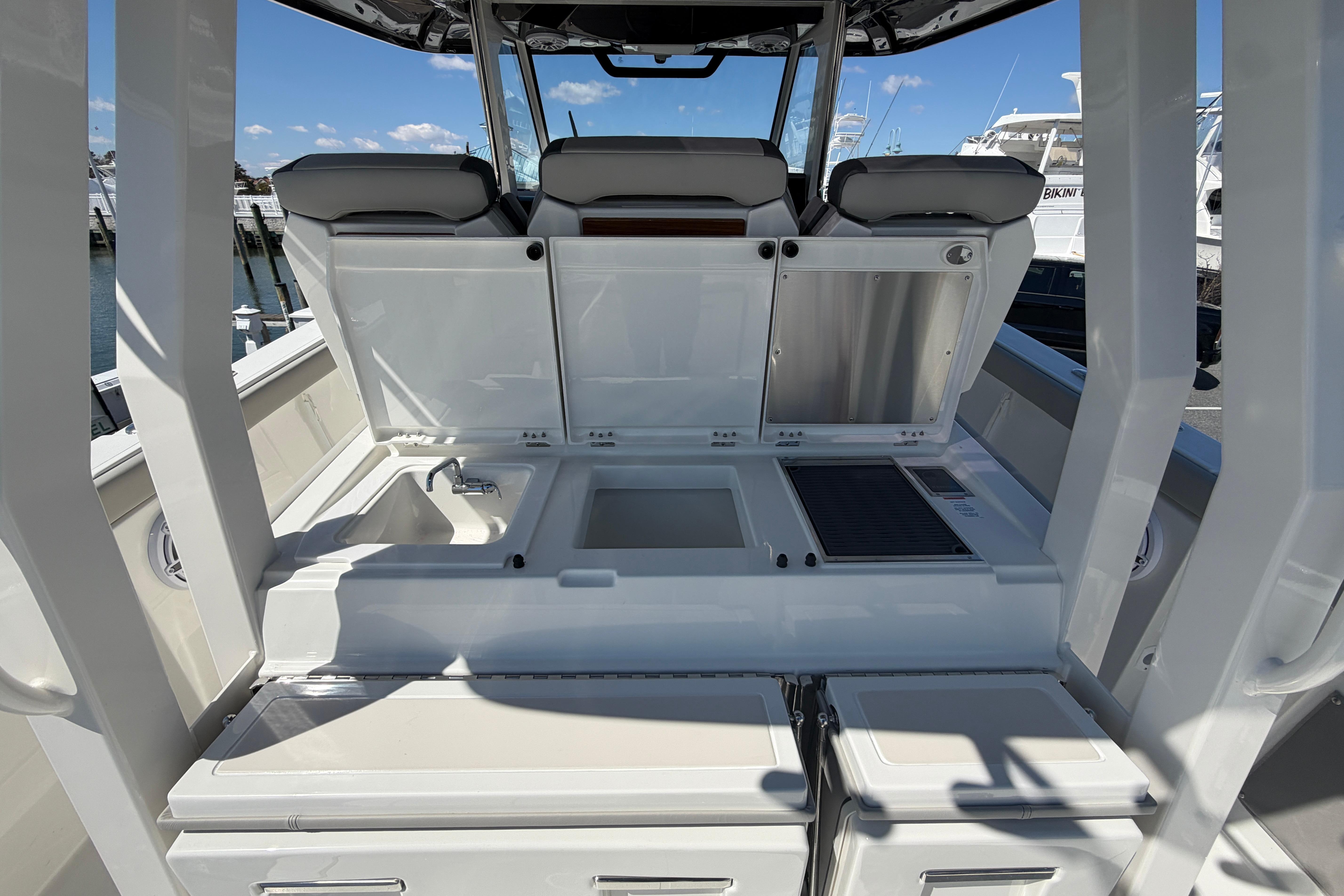 2026 Pursuit S 358 Sport boat interior with open storage compartments and sink.