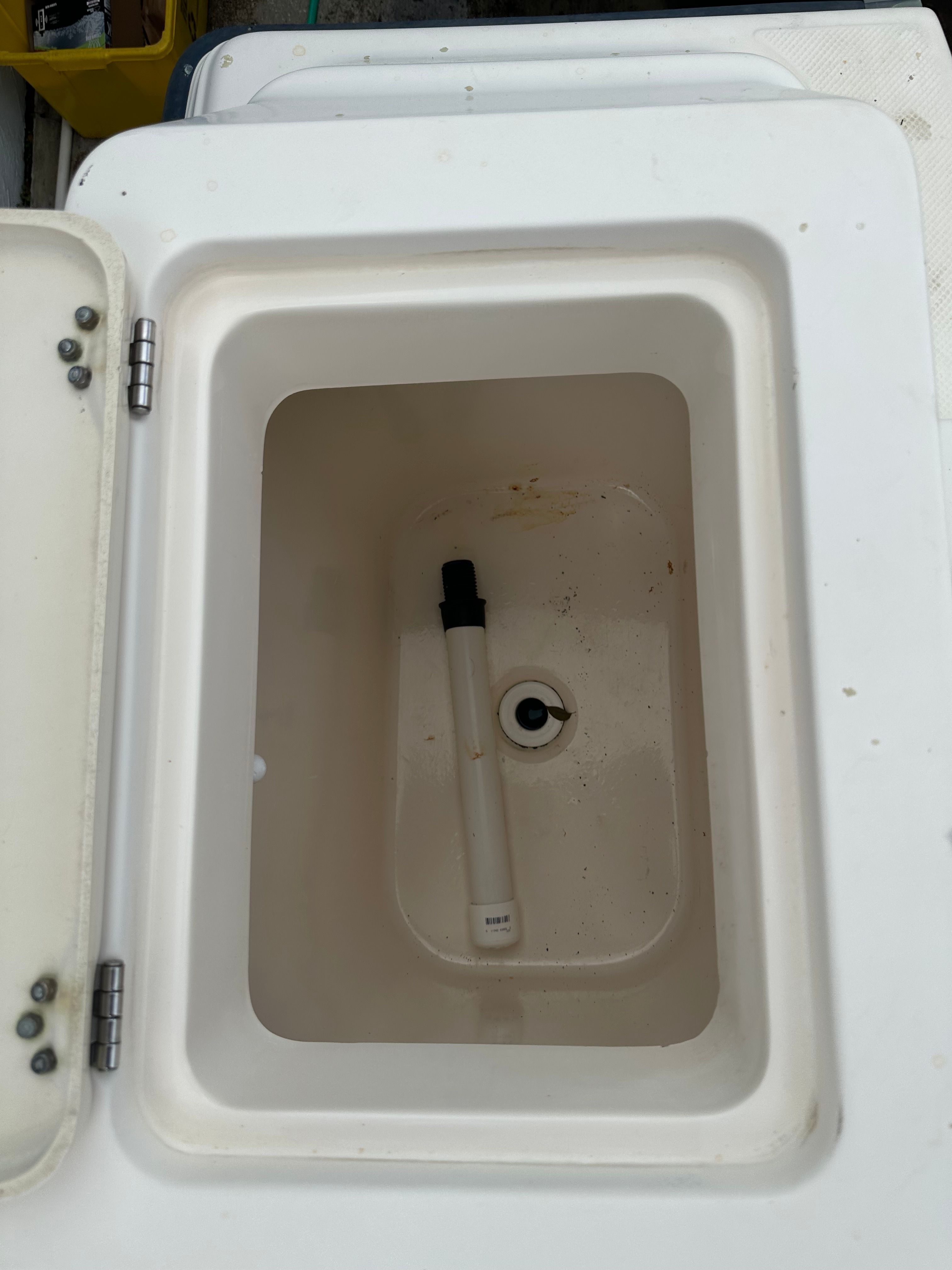 An open compartment on a boat with a drain and a pipe.